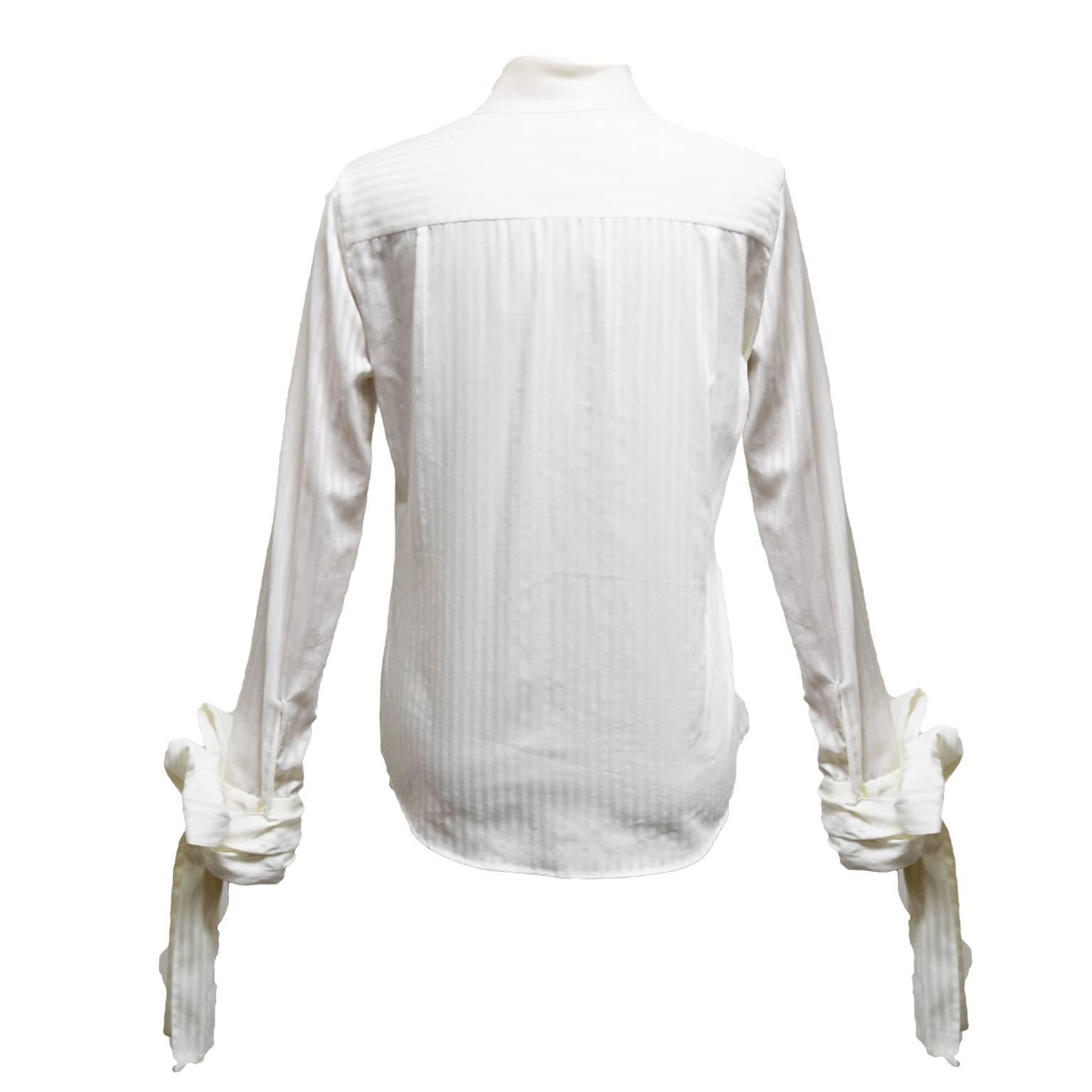 This amazing blouse by Viktor & Rolf is a cotton and silk blend, has a petter pan collar, is silk breasted, striped printed, and has tied bows at the end of each sleeve. 