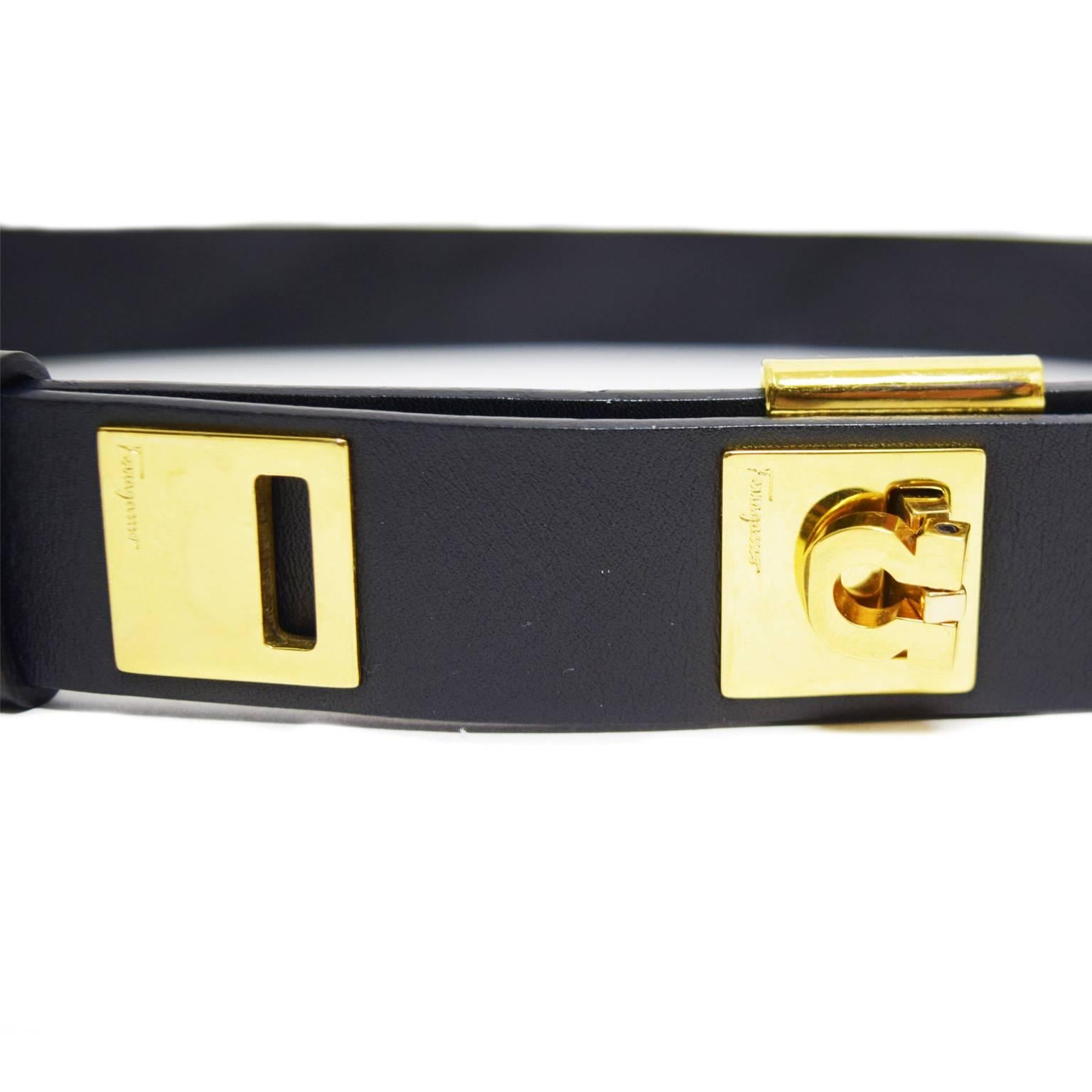 This belt by Salvatore Ferragamo is made of black Italian leather and has gold bucked hardware with engraved logo. The buckle is a magnetic mechanical lock that snaps in between each space. 