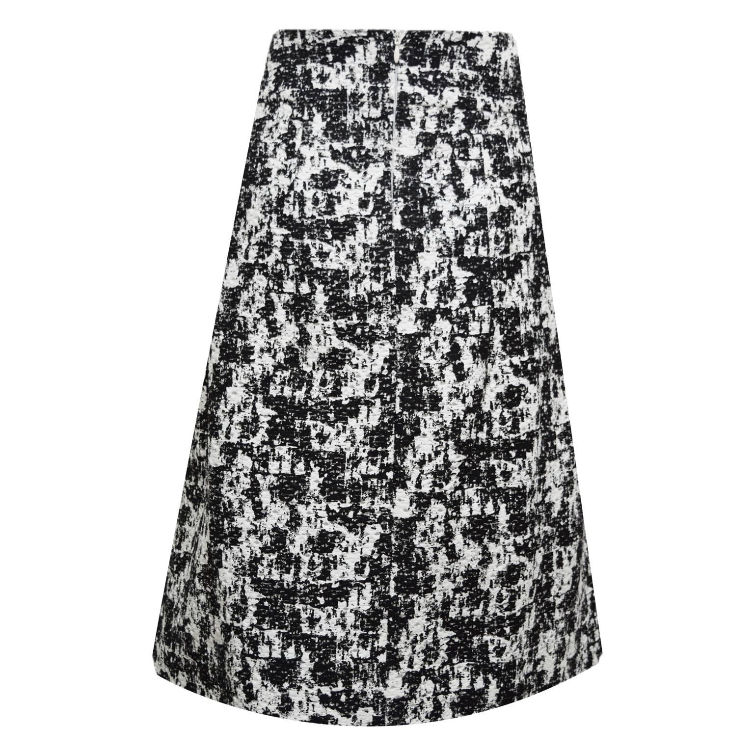 This beautiful Oscar de la Renta Aline skirt is black and white abstract speckled print cotton, polyester blend. The skirt is fully lined with silk and there are front and back knife pleating details. There is a back zipped closure and it is brand