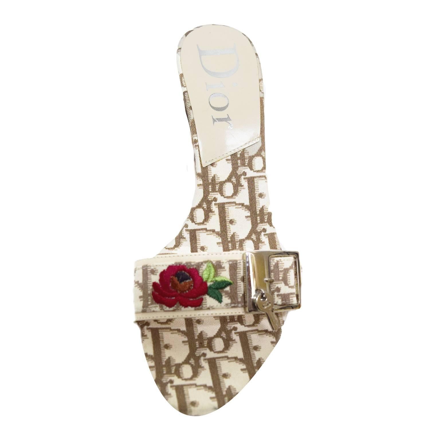 These Dior Sandal Heels are great for summer. The upper strap and inner sole is incased in monogramed ivory and espresso printed fabric. The heel is a short cube heel that measures at 3 inches high. On the upper strap is a embroidered floral design
