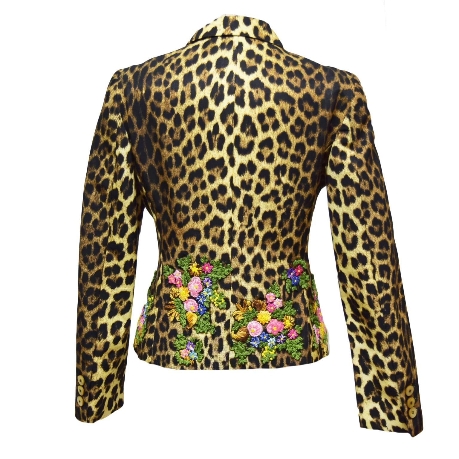 This beautiful two piece by Moschino and fun and the epitome of fierce. It is leopard print with a multicolored floral embroidered border along the bottom of the skirt, jacket and sleeves. Both the jacket and skirt are fully lined and the skirt has