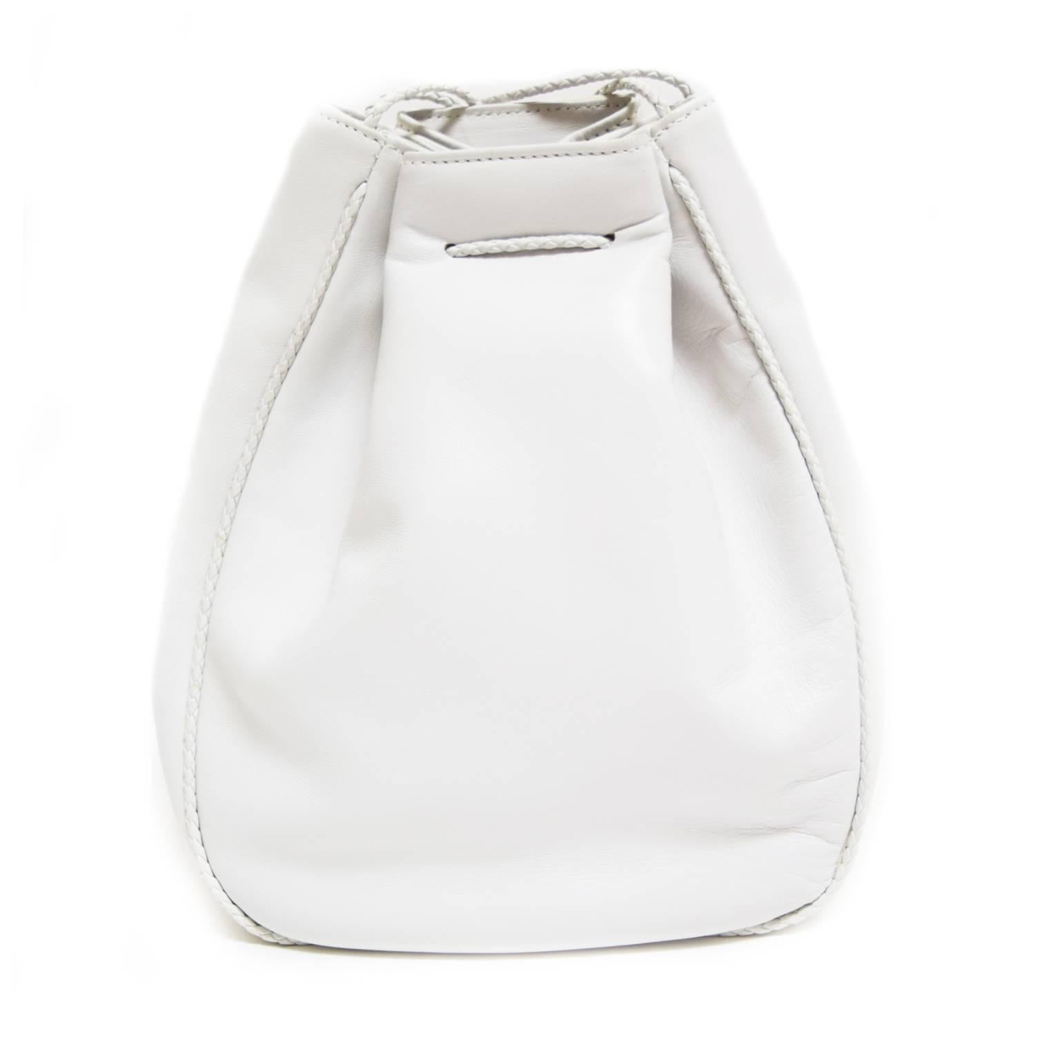 This beautiful white leather handbag by Desmo is a great accessory. The straps are braided leather and continue along the outside of the bag creating a border. The straps are adjustable and there is a tie and snap closure. 