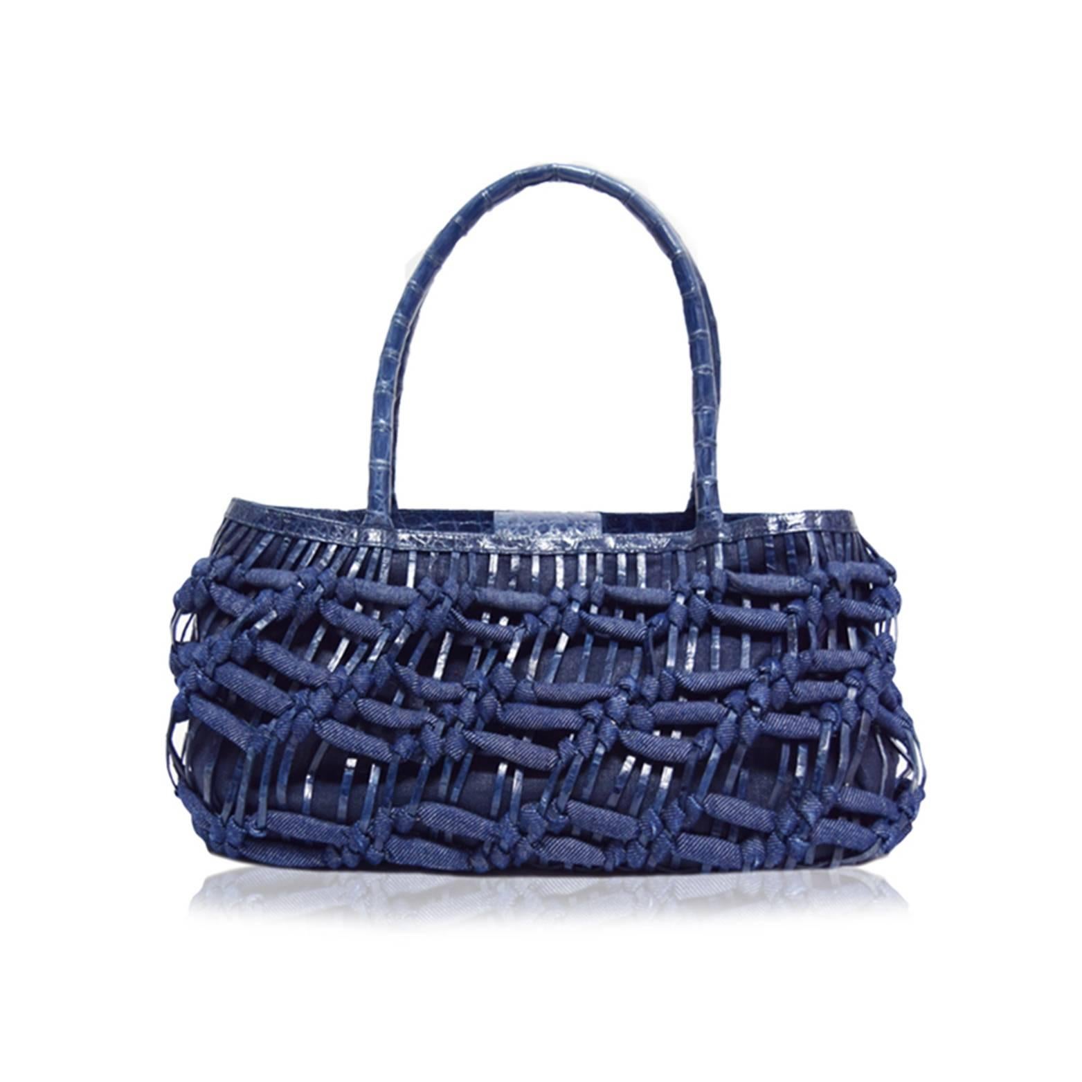 Denim and leather woven fabrication
Navy blue suede lining
Basket style
Crocodile leather handles 
Magnetic snap closure 
Interior zipped pocket
7.5