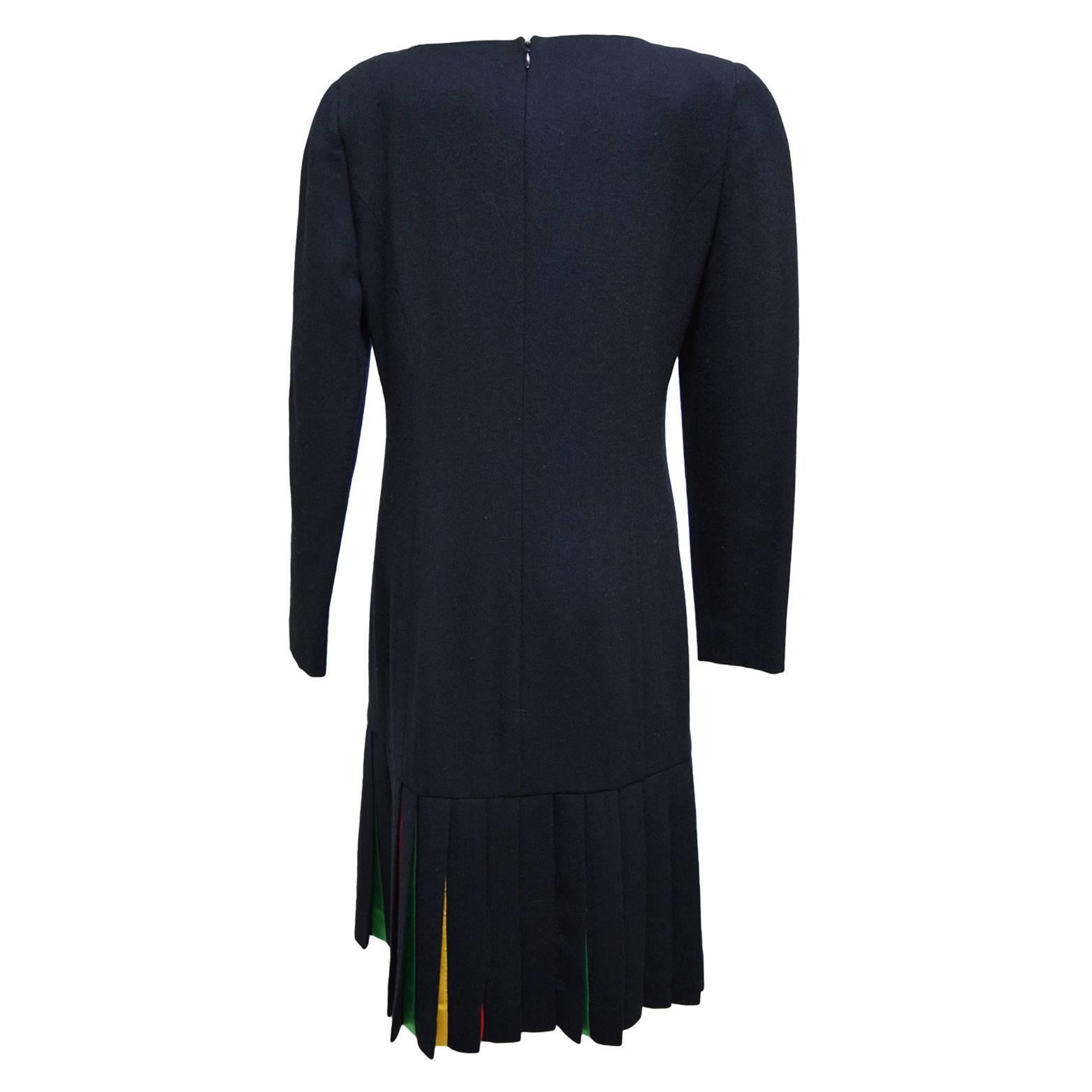 This beautiful vintage piece by Carolina Herrera is made of black wool and is fully lined in silk. The dress is long sleeved with a back zipped closure and the bottom is a colored panel knife pleated skirting.
