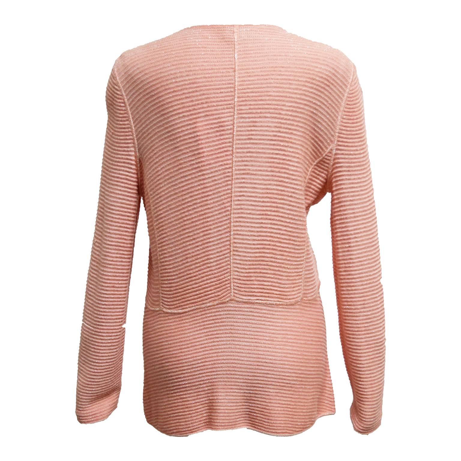 This great piece by Armani is a salmon pink wool blend and is long sleeved. There are ribbed detailing along the bodice and the sleeves and has a button closure. 