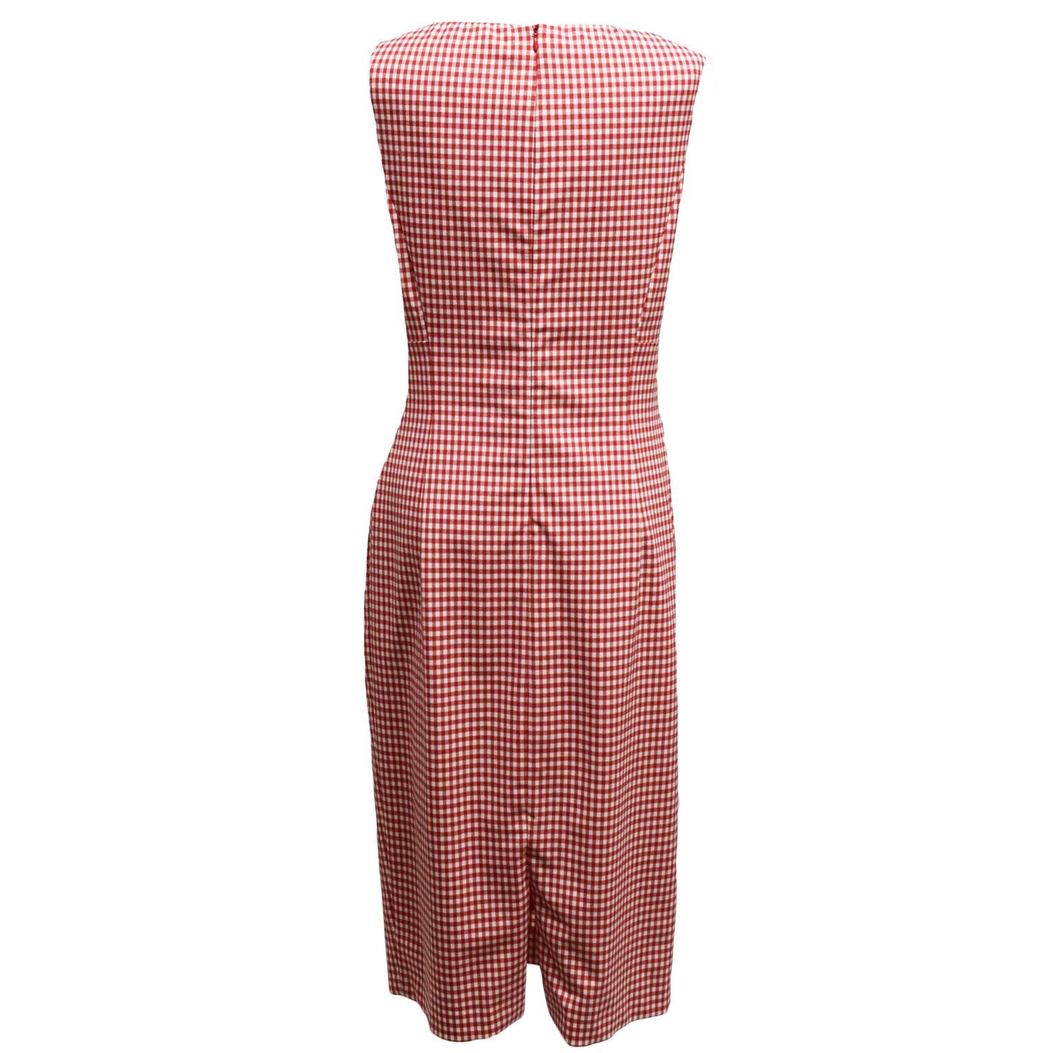 This Michael Kors dress is great for summer. Made from 100% cotton, this dress is a red and white printed gingham. The bodice is a wrapped like look while the neckline is a slight v-neck. The back has a zipped closure. 