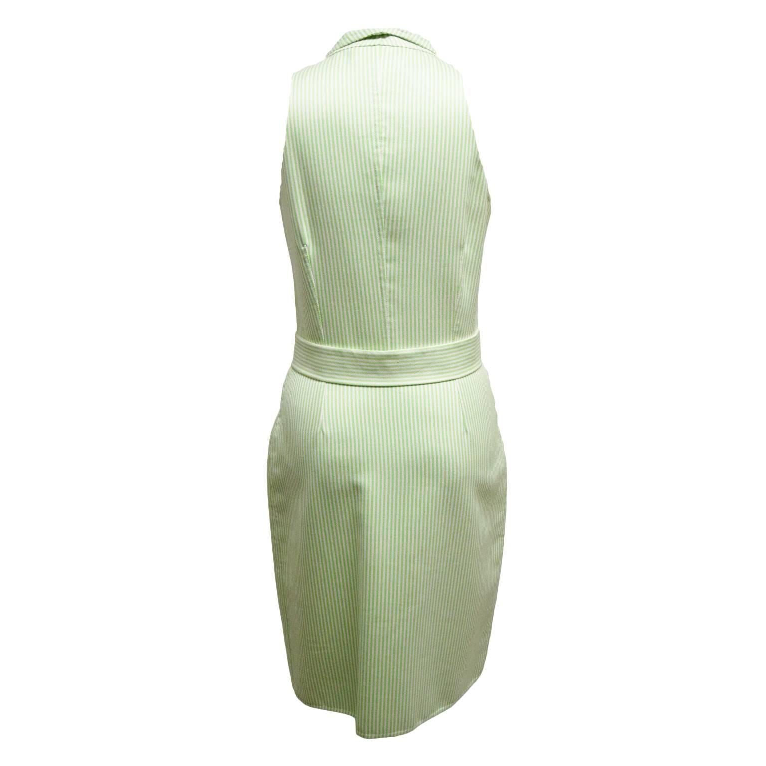 This effortless dress by Oscar de la Renta is made from 100% cotton. The print is a lime and ivory striped print and the dress is shirt waisted. The dress also has a detachable waist belt. The dress has frontal button closures, is sleeveless, and