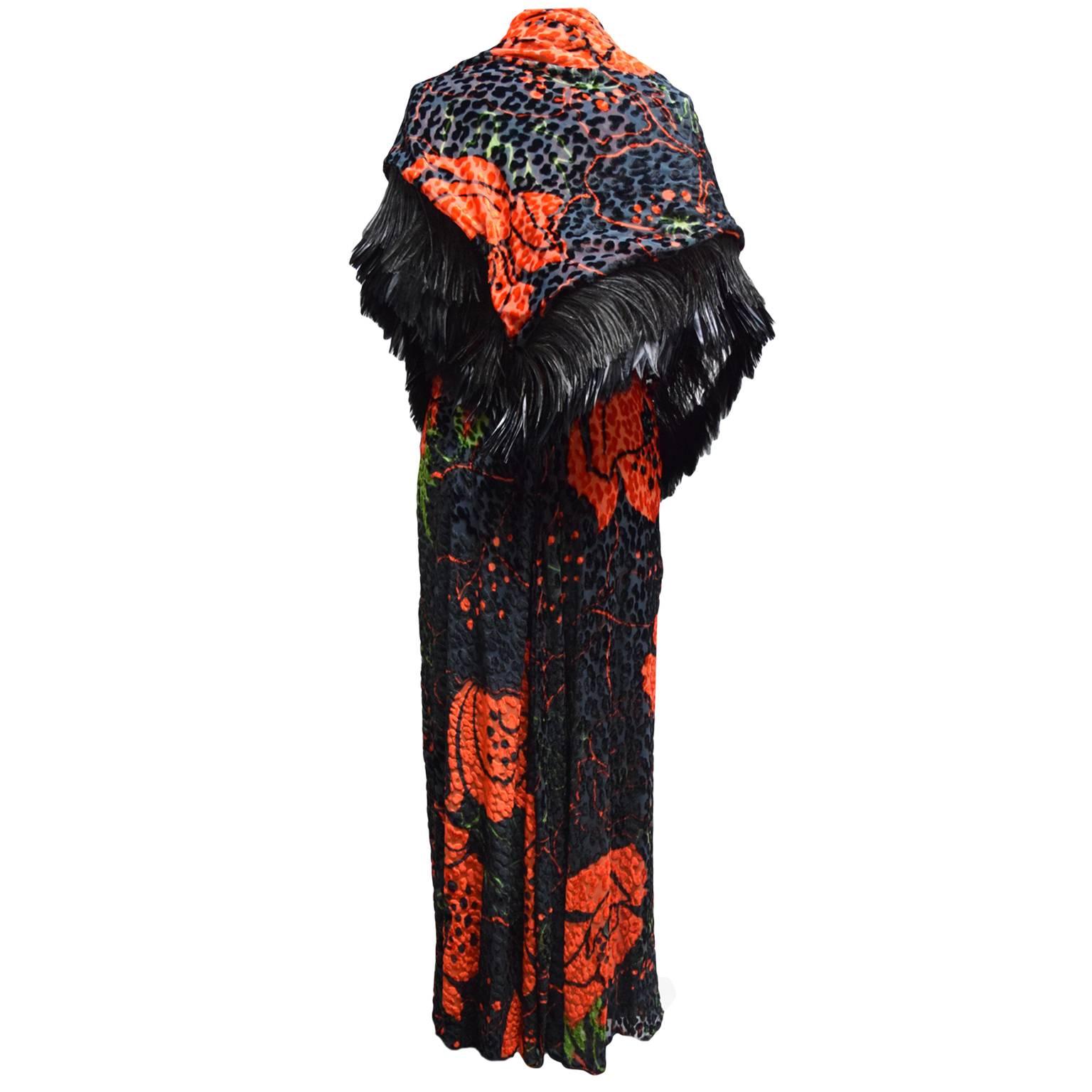 This beautiful ensemble by Bill Blass has a unique taste. The fabric is made out of black and red velvet and has a  specialized burnout technique creating a floral leopard print. The dress is a haltered evening gown and the shawl has black ostrich