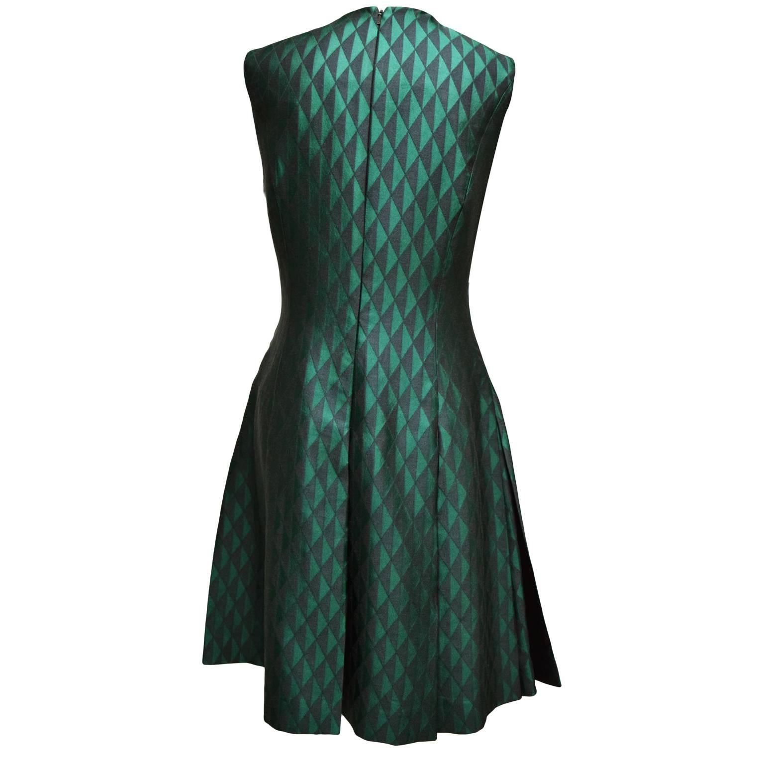 This gorgeous dress by Jonathan Saunders is a wool, polyester, and silk blend. The print is a black and green iridescent argyle print and is fully lined. The front of the dress is a plunging neckline and has a zipped back closure. The skirt of the