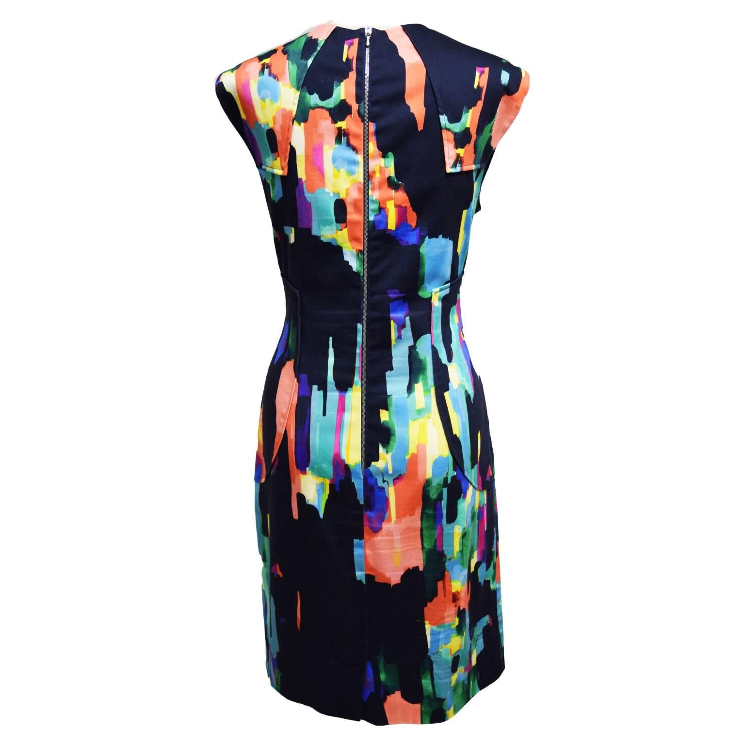 This sheath dress by Lela Rose is 100% cotton and is fully lined making it a refreshing dress for summer. The dress has a multicolored watercolor like paint stroke print and a zipped back closure. The bodice has elongating darts for a more slimming