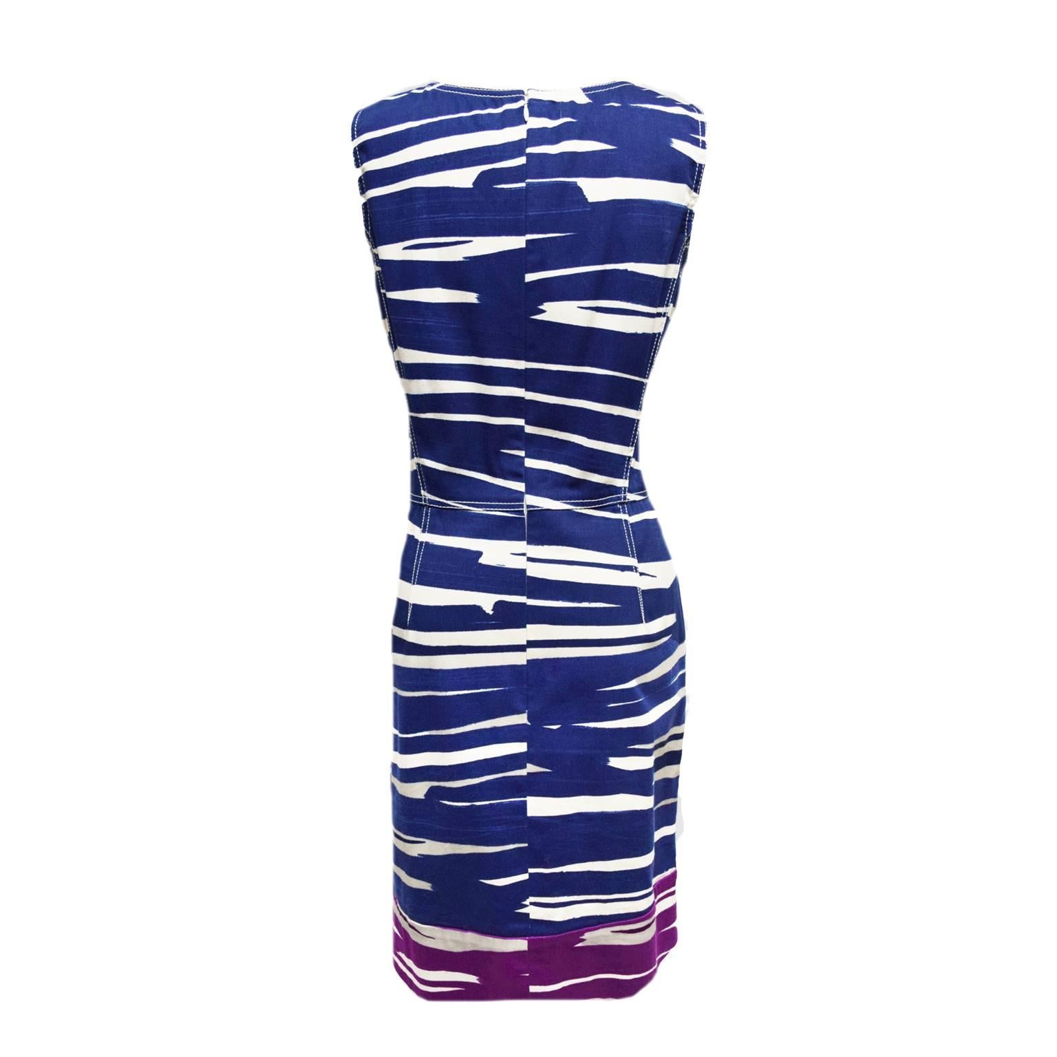 This dress by Oscar de la Renta is made of 100% cotton. The dresses print is an animal like striped print and is color blocked in blue and purple. The dress has an empire waist and a back zipped closure. 