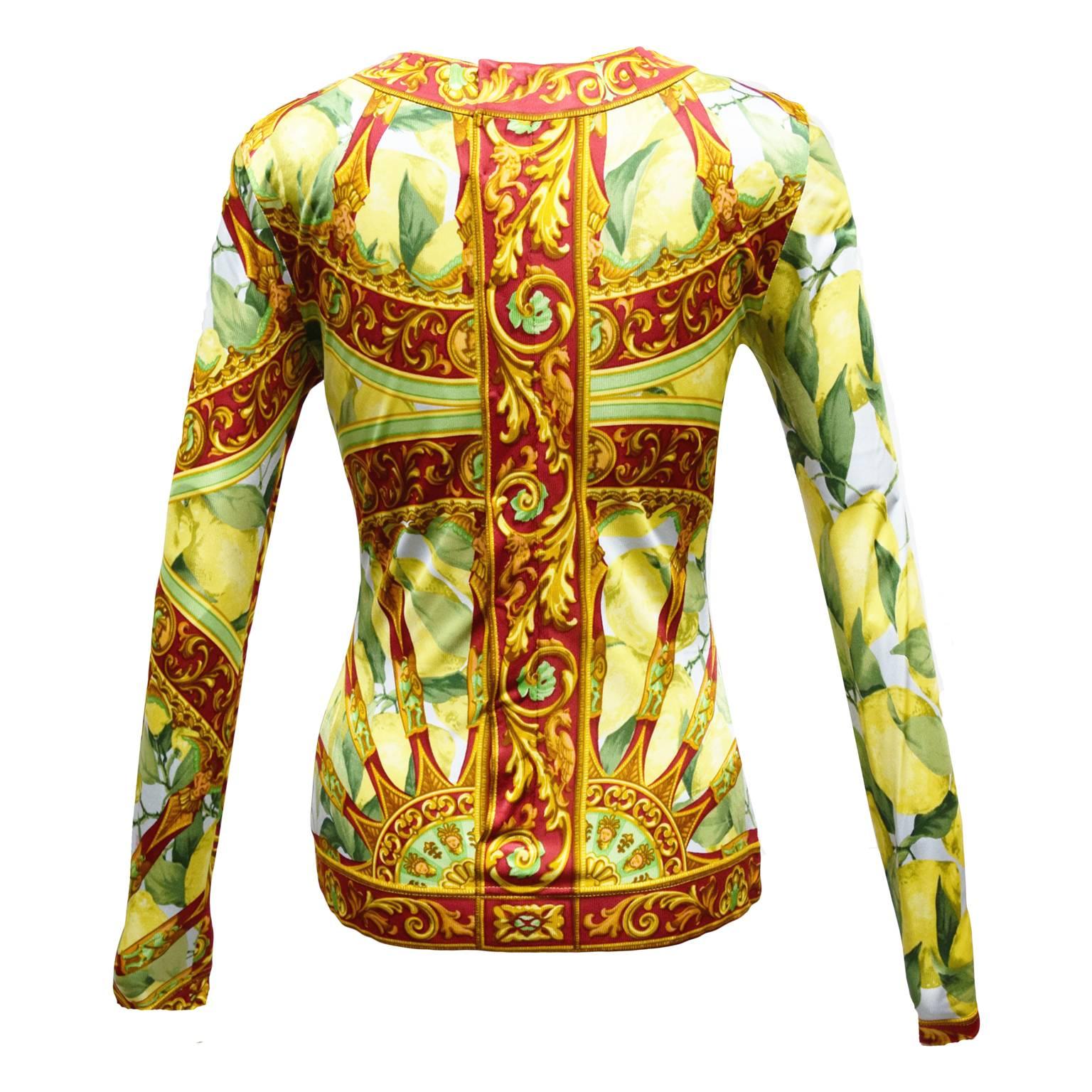 This Dolce & Gabbana blouse is 100% Polyester. The print is a lemon and baroque print. The shirt has long sleeves and a slight V-neck. 