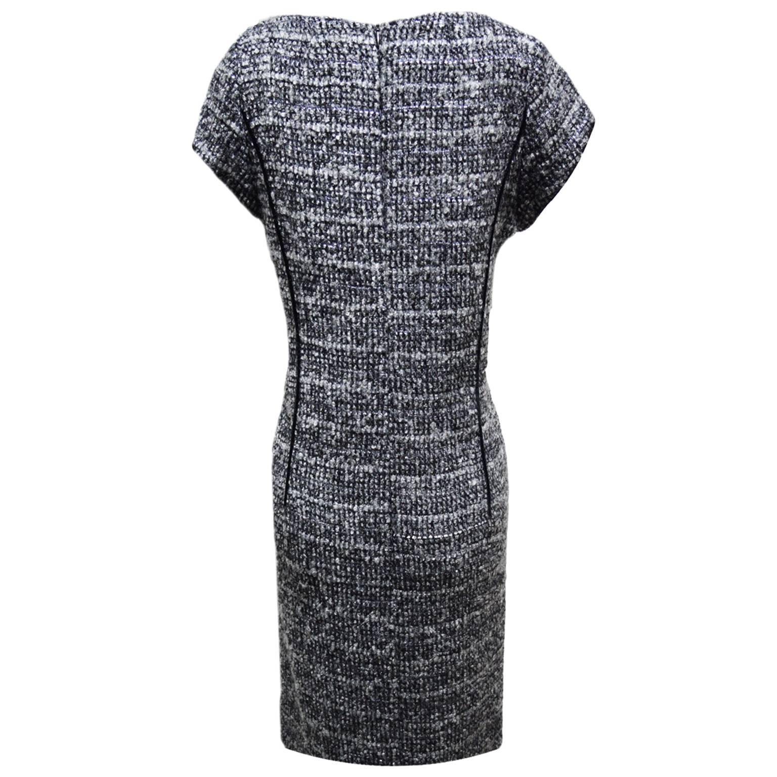 This dress by Lourdes Chaves is 100% wool and is fully lined. The dress is a heather grey print with elongating black piping running along the bodice, creating a slimming look. Zipped back closure. 