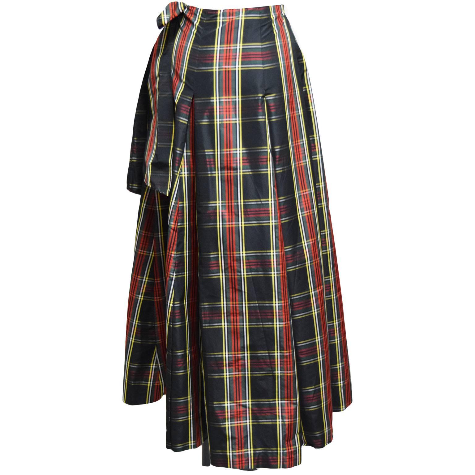 This Moschino skirt is made from 100% silk and plaid printed. The waist inseam button's closed and has a panel that works as a wrap that ties on the other side of the waist creating a full wrap skirt. The skirt lastly has knife pleats to create a
