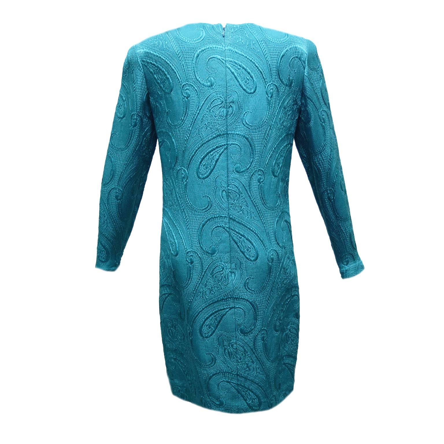 This beautiful dress by Carrolyne Roehm is made from 100% silk and is fully lined. The dress has a paisley Jacquard like imprint and is three-quarter sleeved. The back has a zipped closure and the neckline is an asymmetrical draped cut.