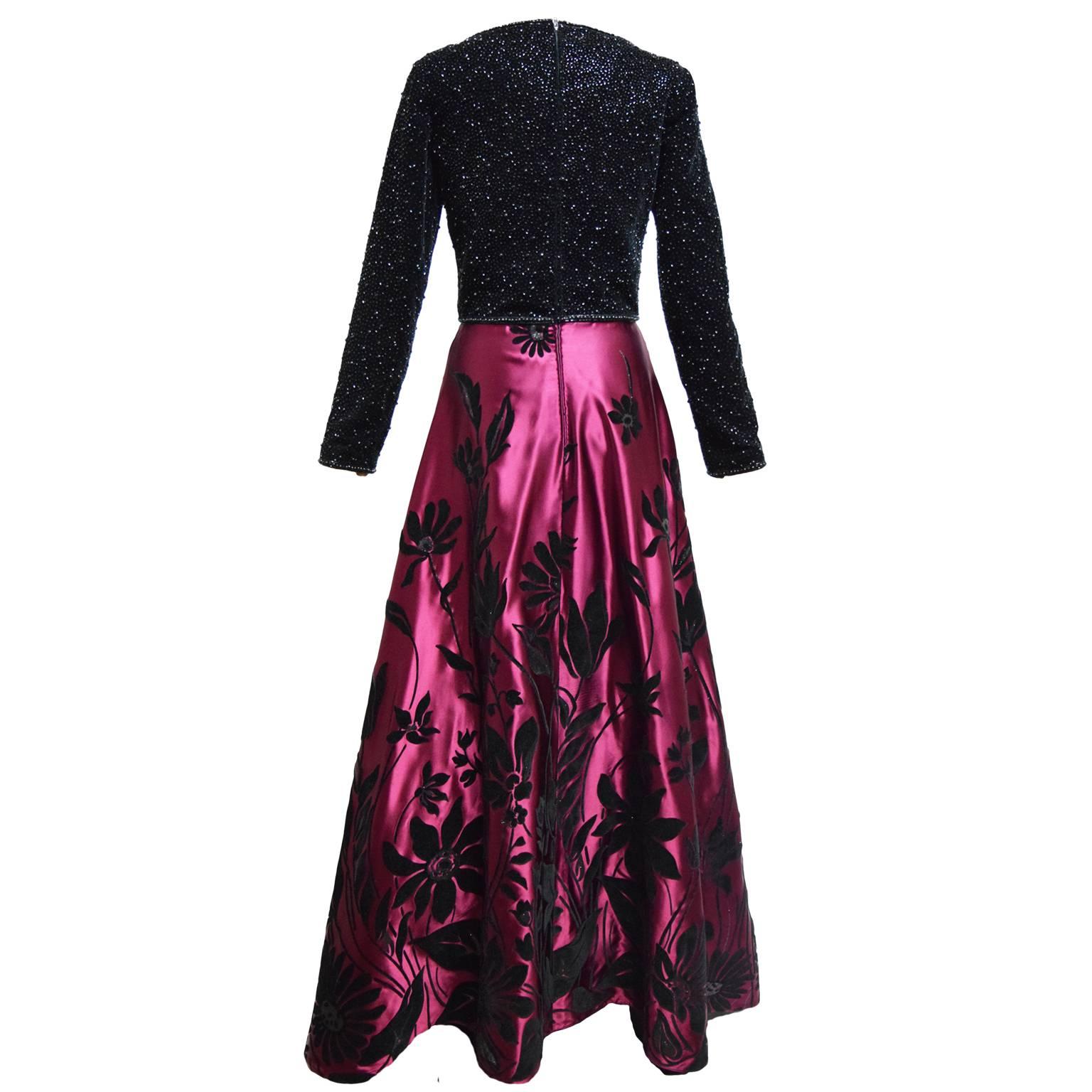 This beautiful evening gown by Victoria Royal is a one of a kind. The bodice is made of rich black velvet and has black crystal iridescent jewel embellishments.  The bodice has a slight sweetheart neckline. The skirt of the gown is a vibrant merlot