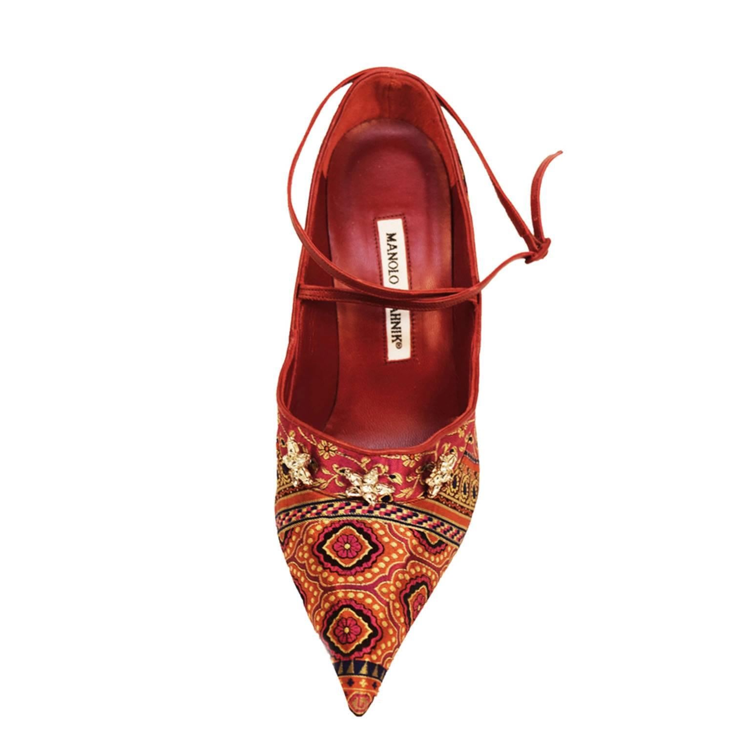 Manolo Blahnik brocade constructed upper with cross around ankle strap. Velvet red leather insole and interior, with cross ankle leather strap. Suede velvet red heel with black top piece and barely worn nude sole. Swarovski Rhinestone star