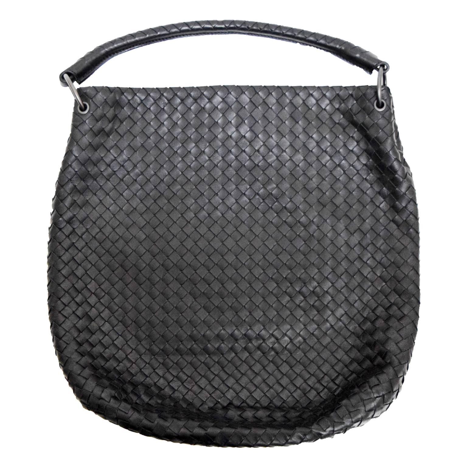 This amazing Bottega Veneta shoulder bag is in excellent condition. The exterior features stunning woven black leather with a unique pleated pattern along the center front and back sides. The top magnetic snap closure opens to a beige suede lined
