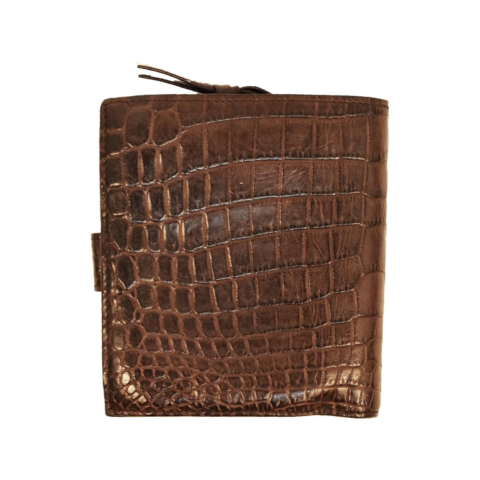 This Bottega Veneta Bi Fold is great for everyday use. Made with 100% Croc leather and soft chocolate brown leather on the inside. Bottega Veneta stamped on inside for authenticity. Snap leather strap closure. Multiple compartments for practical