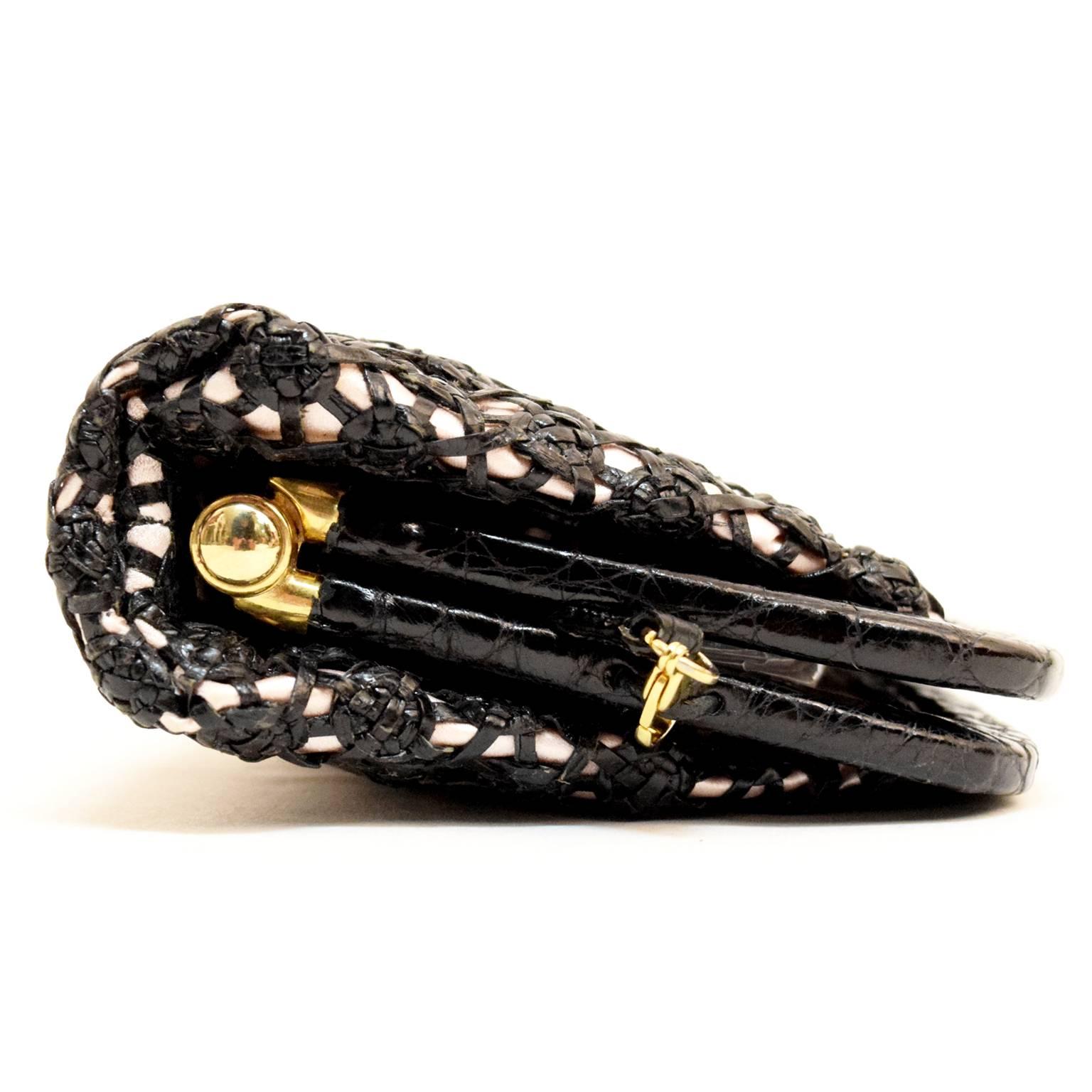This amazing Nancy Gonzalez Clutch can be also converted into a cross body with a removable leather strap. Black Croc is woven into an intricate design formed into little florets with cutout detailing. Lined with 100% pale pink silk and embellished