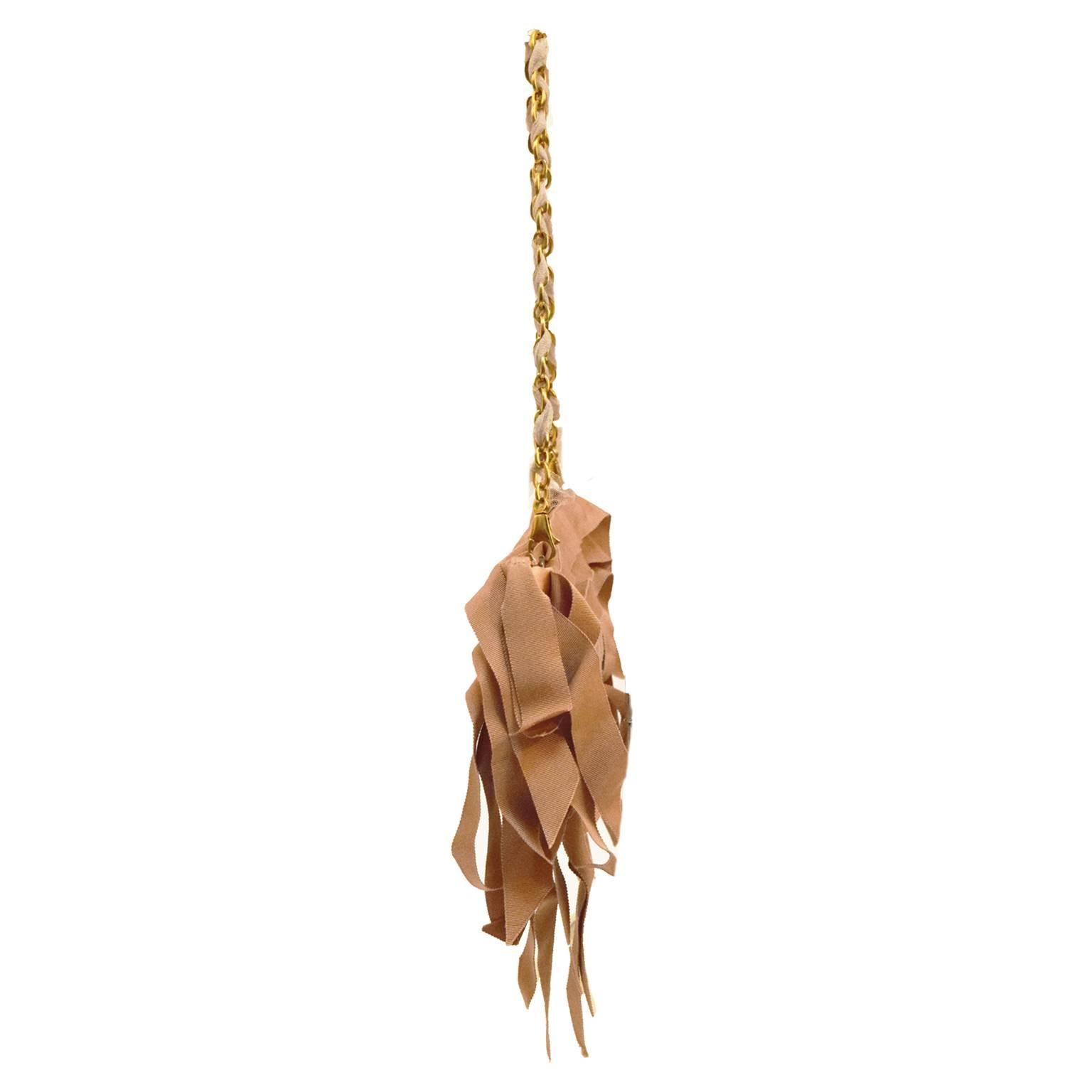 This rare and unique piece is one of a kind. Made out of pale pink grosgrain ribbon, tulle, and gold hardware. This look is the epitome of elegance. 