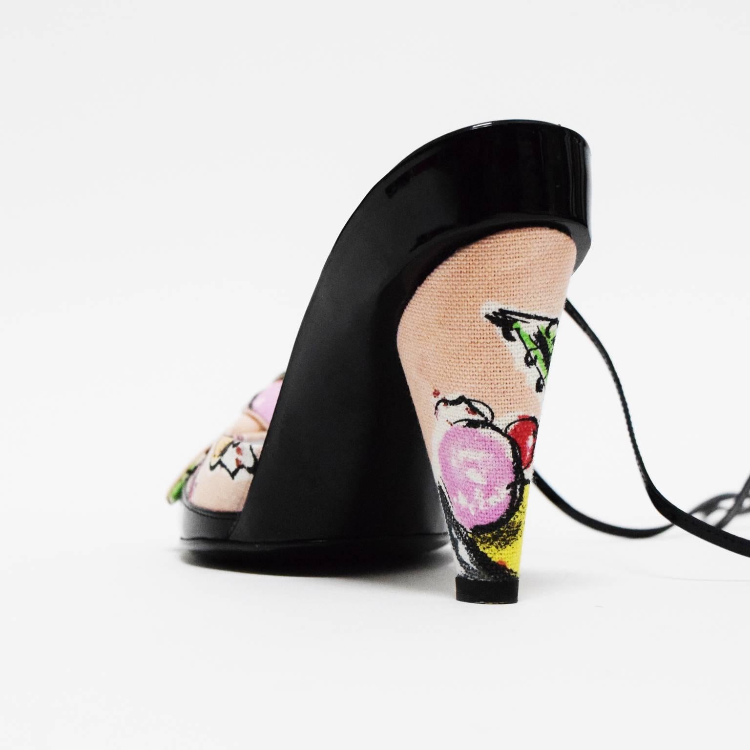 Printed canvas . Black patent leather rounded toe. Leather tie around ankle straps. Upper knotted bow embellishment. 