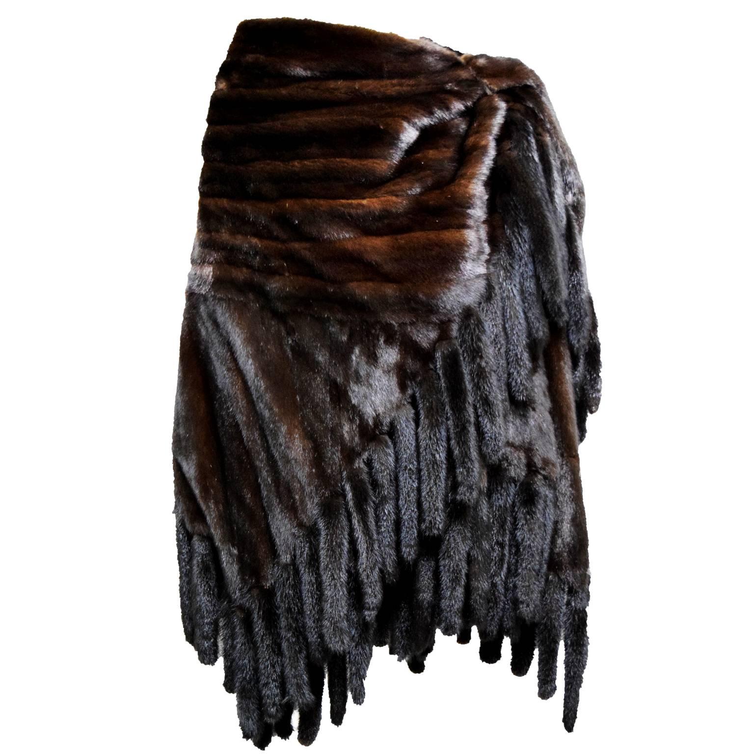 This beautiful Revillon Cape is made out of female mink, and has a rich mahogany undertone. Fully lined in silk, this amazing one of a kind piece has 96 mink tail and can be worn in many versatile ways. 