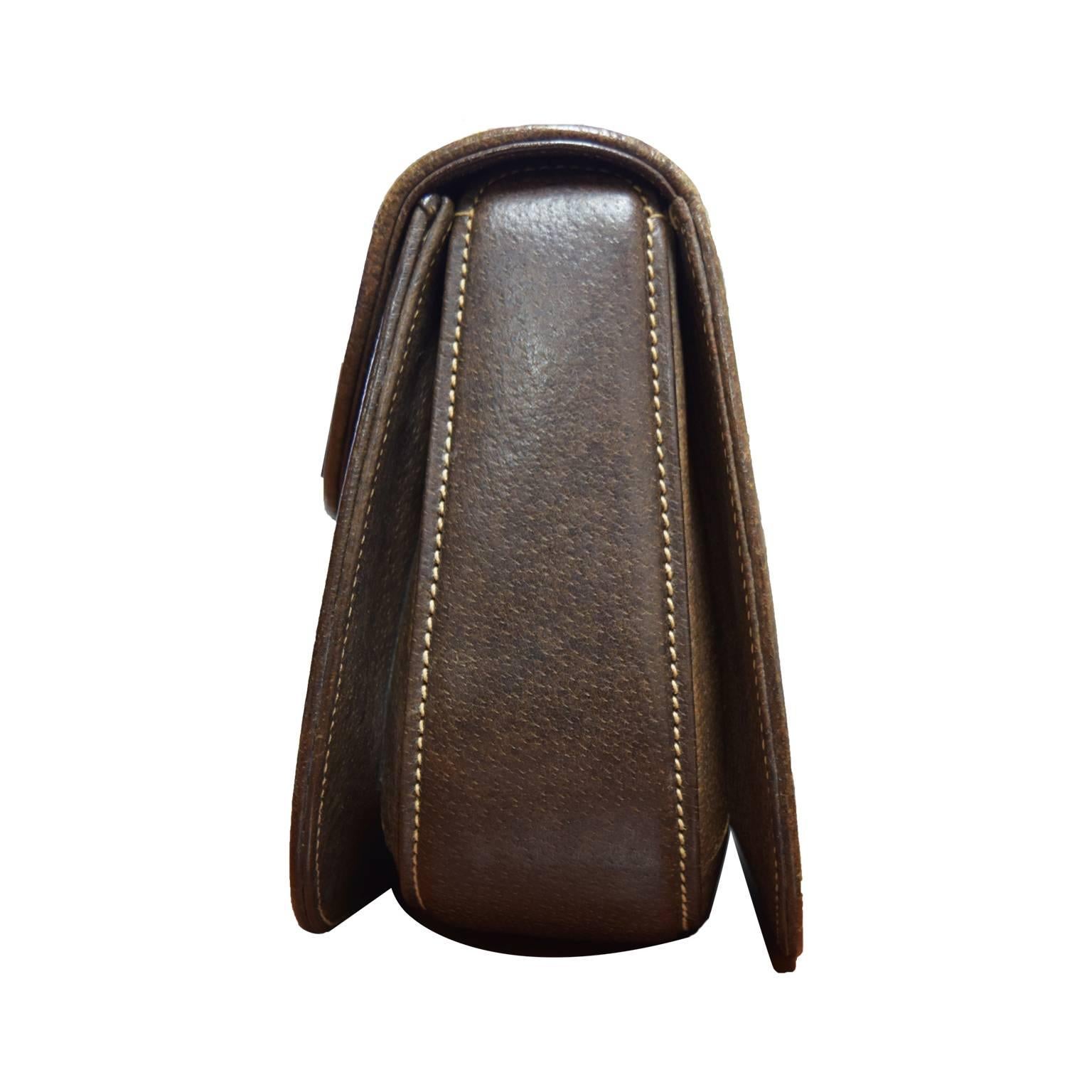 This Gucci handbag is a classic. Made from their signature logo covered canvas,   and rich deep leather on the inside and out. There is a bamboo notch closure that contrast with the bamboo top handle. Gold hardware. Pristine condition.  