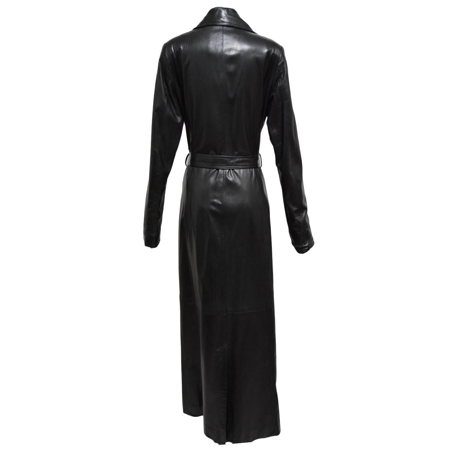 This classic piece by La Nouvelle Renaissance is made of smooth rich black leather and is fully lined in silk. The Jacket itself has a trench coat style, front pockets, gold button closures and a belted waist. Great for a rainy day in the city. 