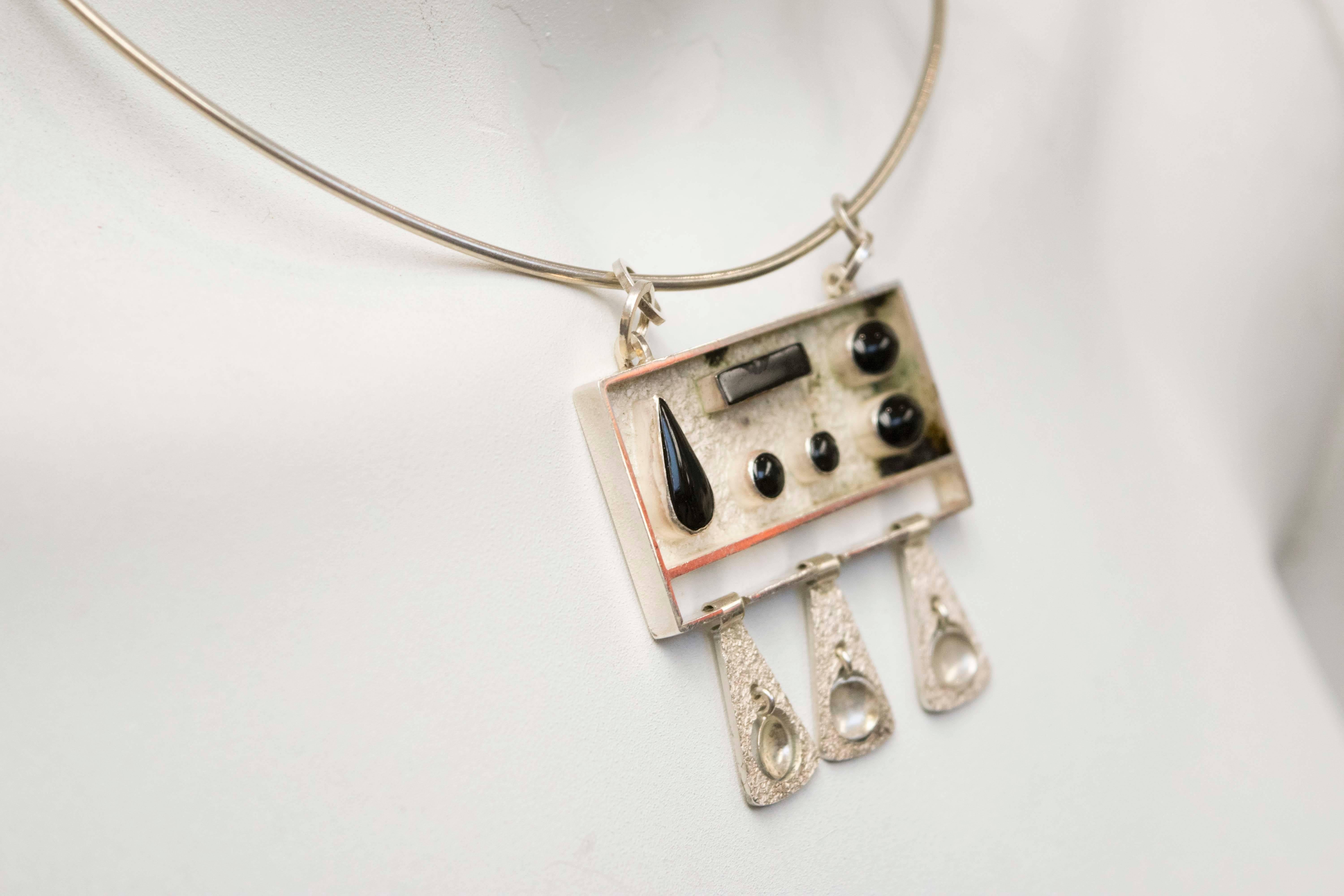 Oswaldo Guayasamin (Ecuadorian, 1919-1999), necklace, sterling silver and onyx. A large rectangular pendant holds six onyx stones, three triangular pendants with swinging cutouts are suspended beneath. 