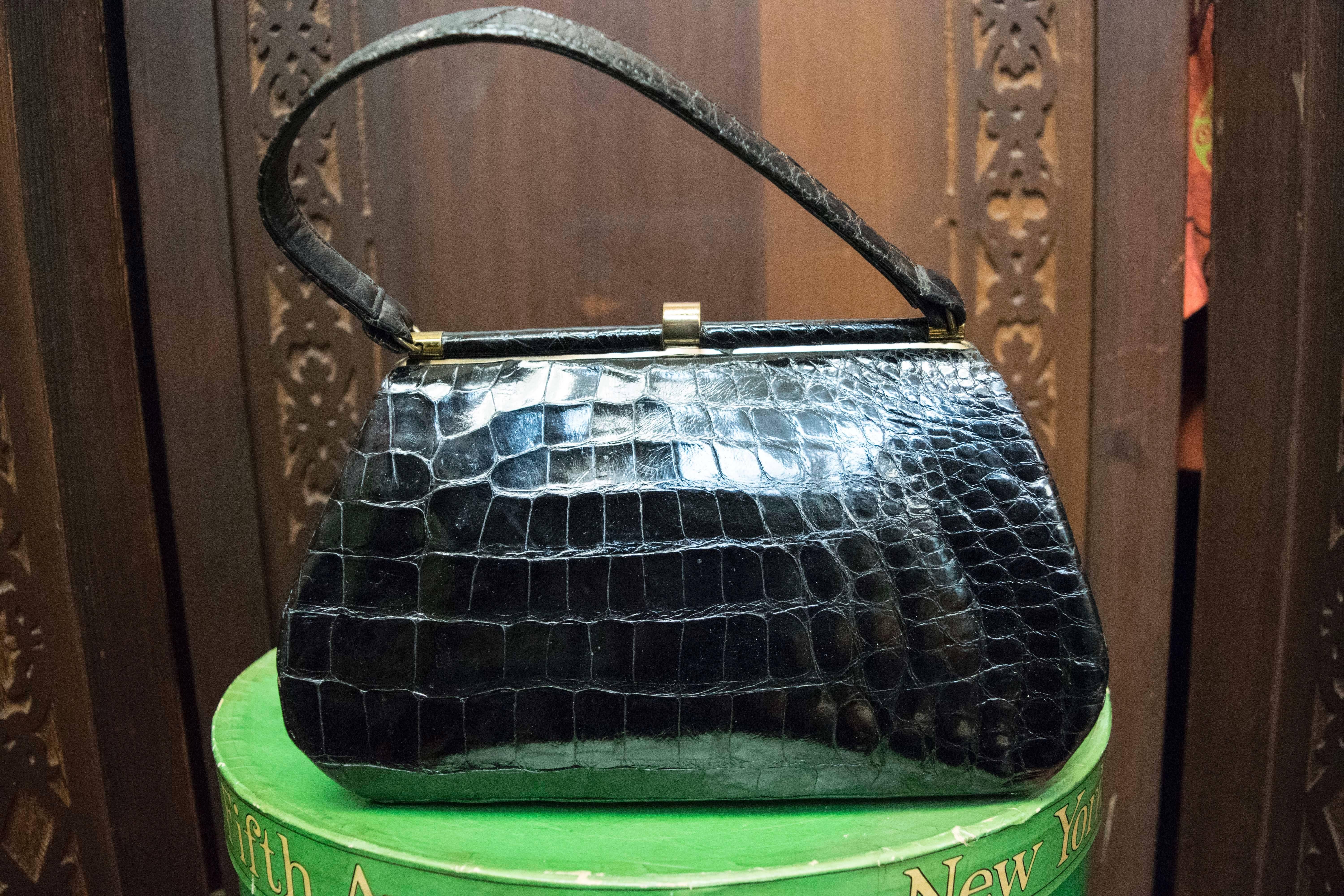 1950s Bellestones Black Alligator Handbag

This bag is lined in red leather and comes with original compact and coin purse.

L 10.5
H 6.5
D 3.5
