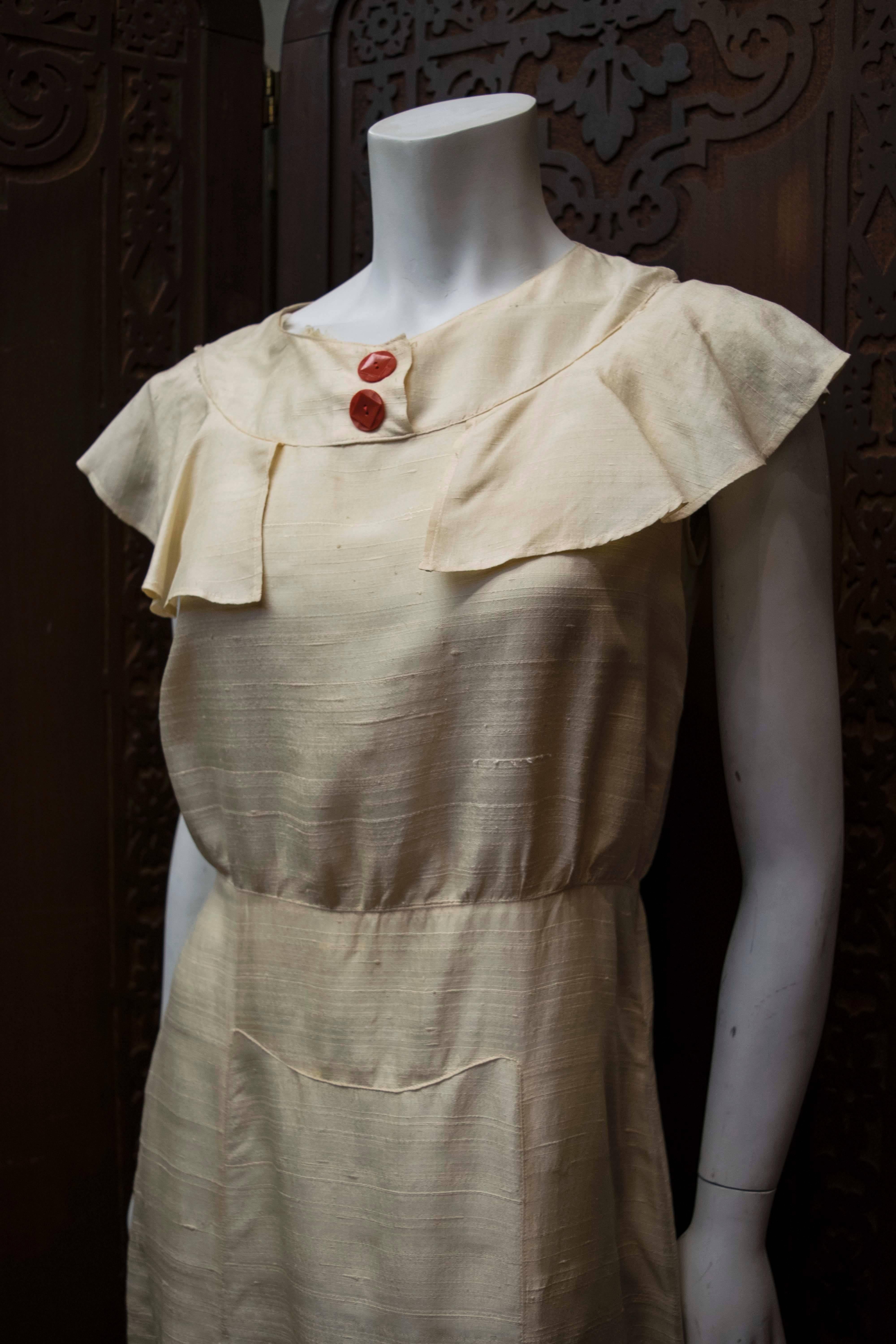 Late 1920s Raw Cream Silk Dress

Stunning dress circa 1929/1930, made from raw silk and featuring red bakelite buttons. Completely wearable.  

B 38
W 30
H 40
L 49
