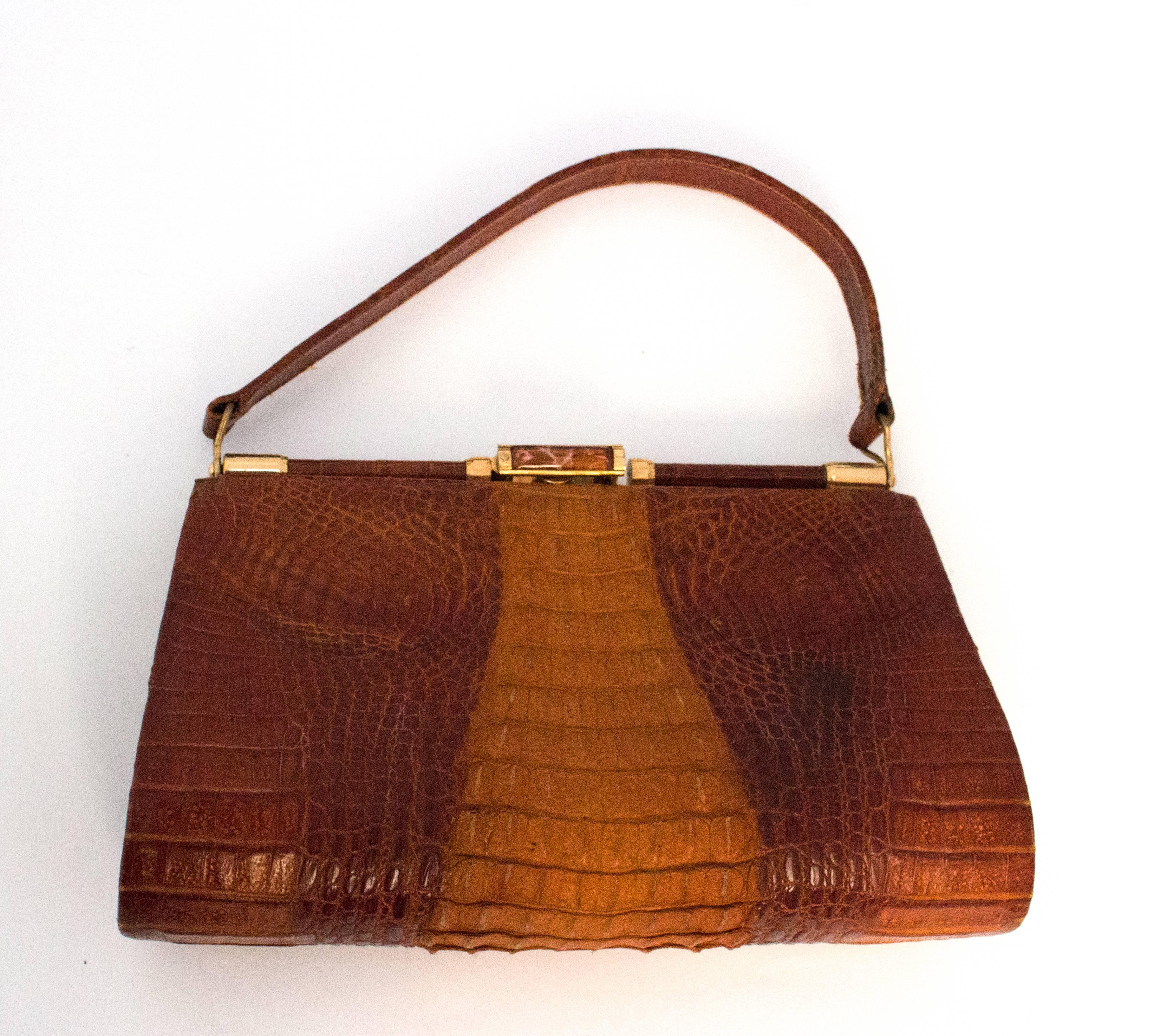 50s hornback alligator handbag. Small art glass detail on frame lock. Three interior pockets, one is zippered. 

Measurements
Width: 9 1/4 - 10 1/2 inches
Height: 16 inches
Handle: 13 1/4 inches 
