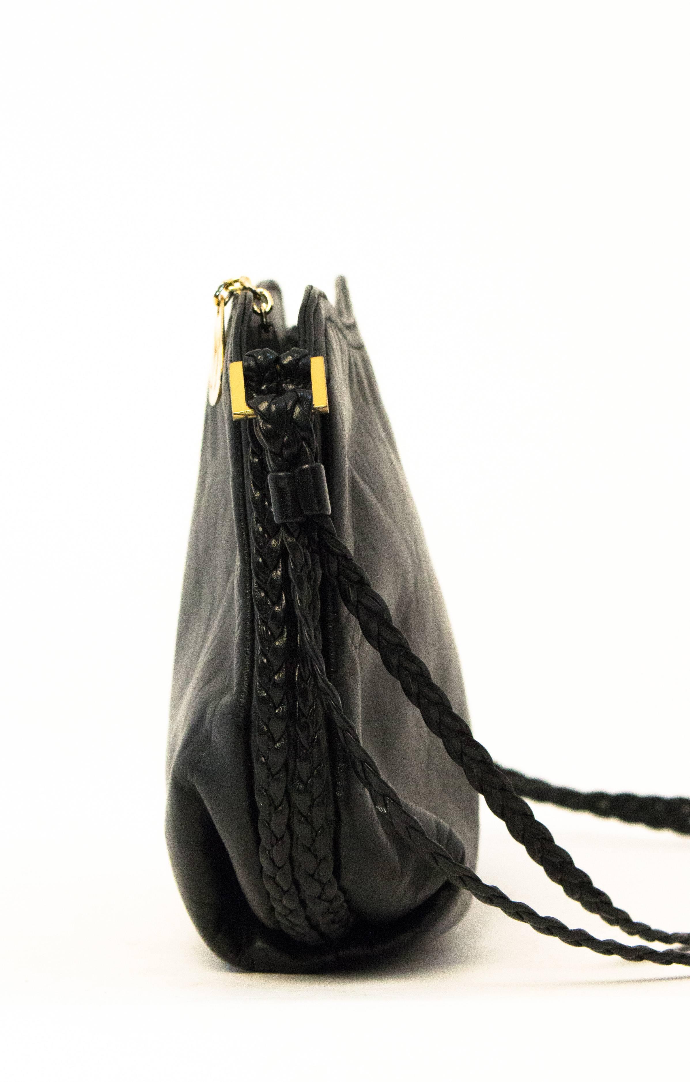 80s black leather Morris Moskowitz purse with braided strap and trim. Gold tone hardware. One zippered interior pocket.Grosgrain lining. 

Measurements:
Width: 9