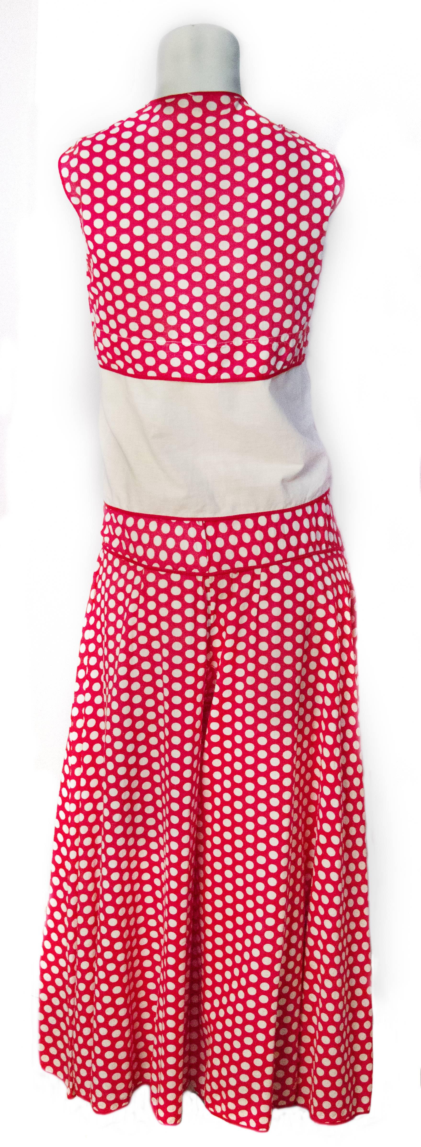 30s red and white polka dot cotton lounge set. Top design features faux polka dot vest and attached bow. Palazzo pant has side button closure. 