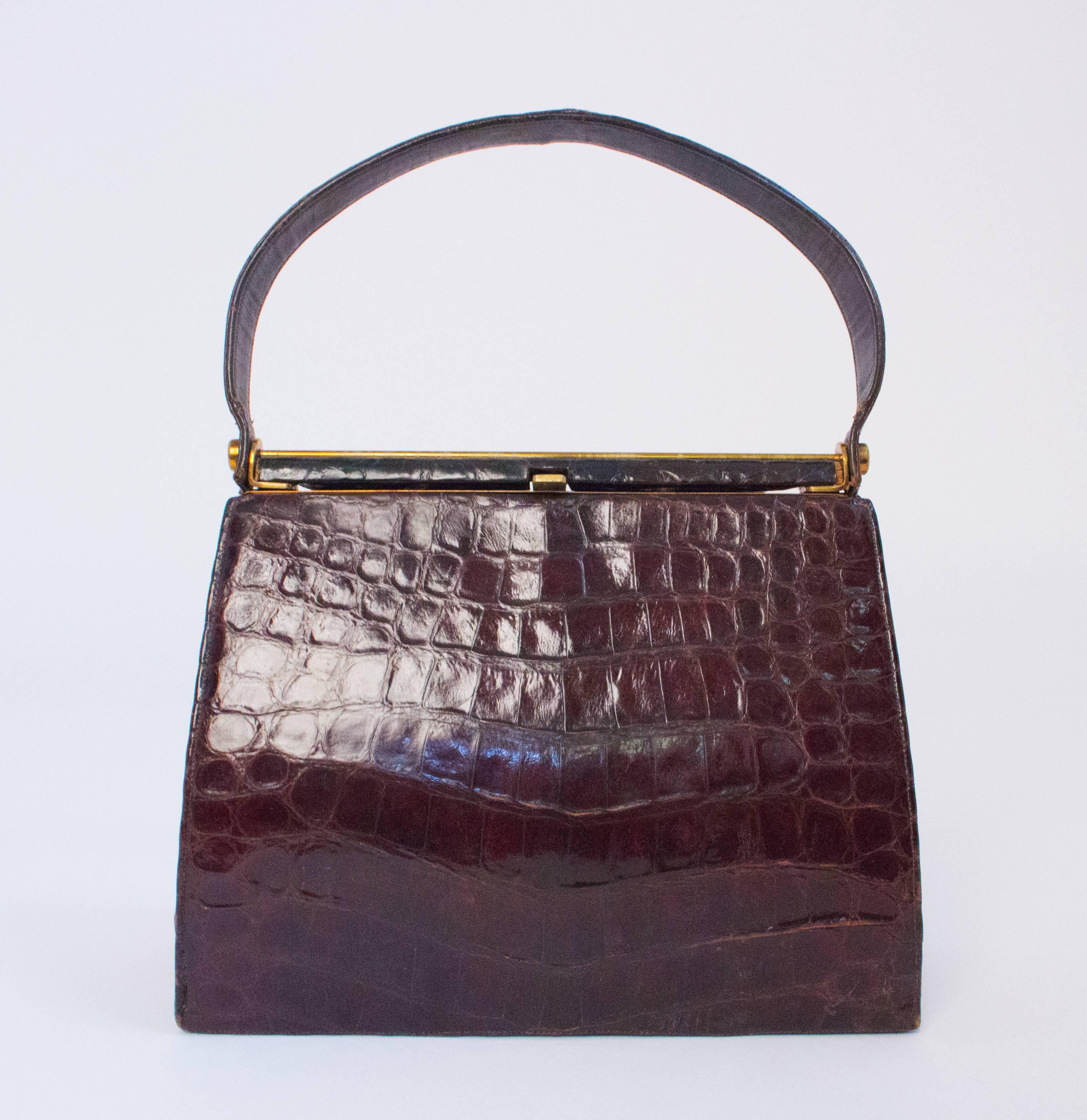 50s / 60s alligator handbag. Gold tone hardward. Leather interior. 3 interior pockets. I interior zippered pocket. Has feet.

Measurements:
Body of bag: approx. 10 1/2 x 9 inches 
Handle: 17 inches 