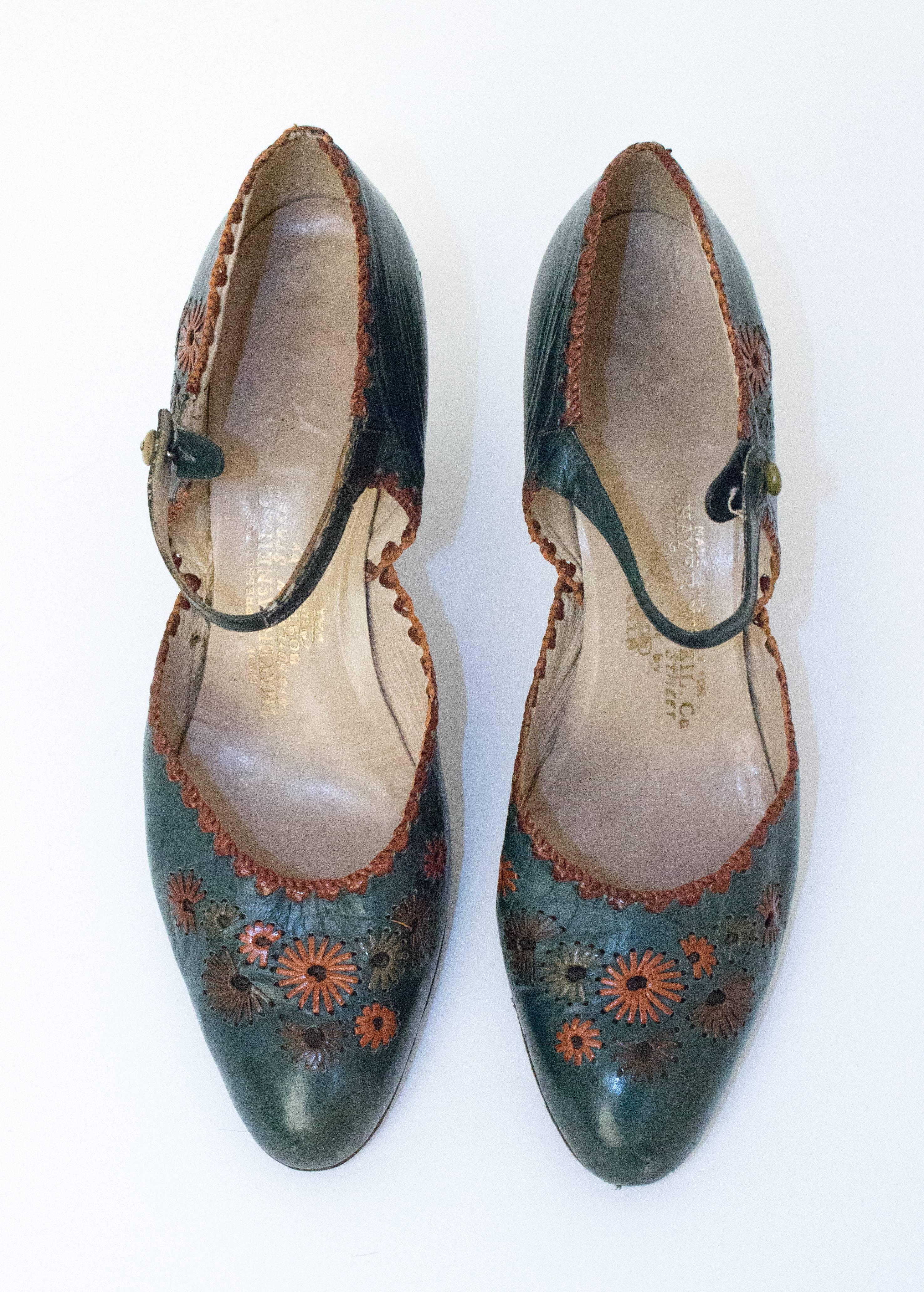 chaussures à talons en cuir vert des années 20 avec des embellissements floraux. Semelles en cuir. Boutons en bakélite. 

Mesures :
Semelle intérieure : 9 1/2