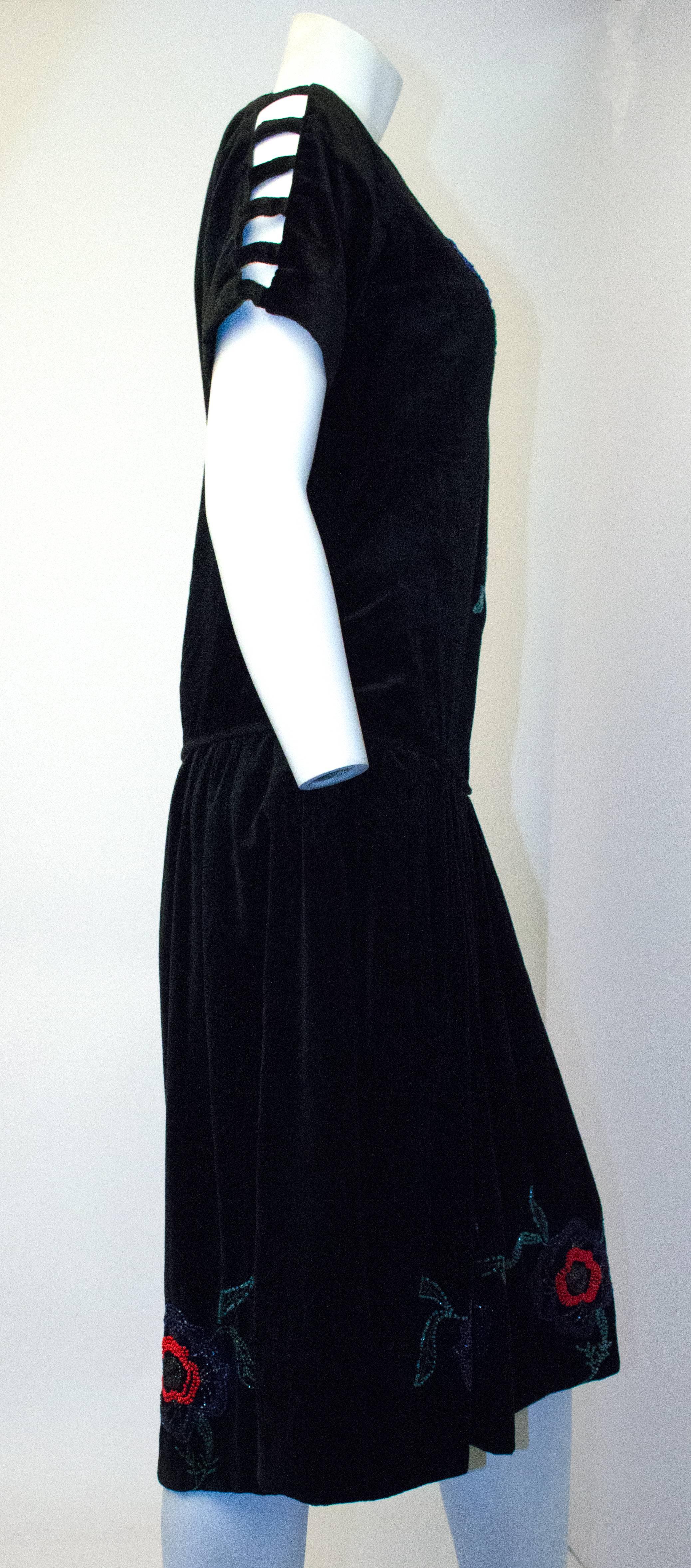 20s Black Velvet Dress with Floral Beadwork. Cutout strips along top of shoulders/arms. Snap closure entry along left side and shoulder. Unlined. 