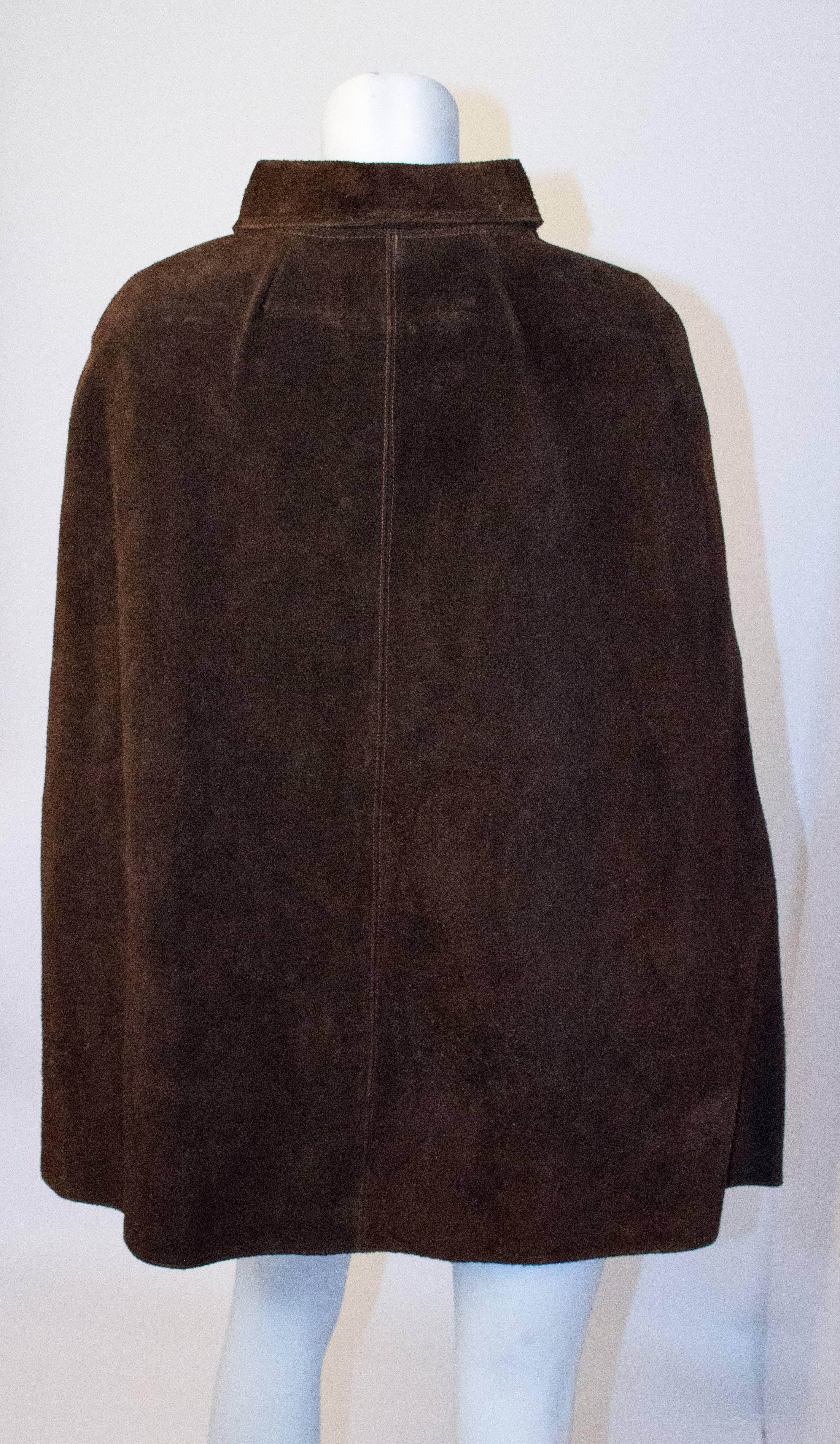 70s Chocolate Brown Suede Cape with White Piece Work. Arm holes. Two front pockets. Metal zipper up the front. Unlined. 