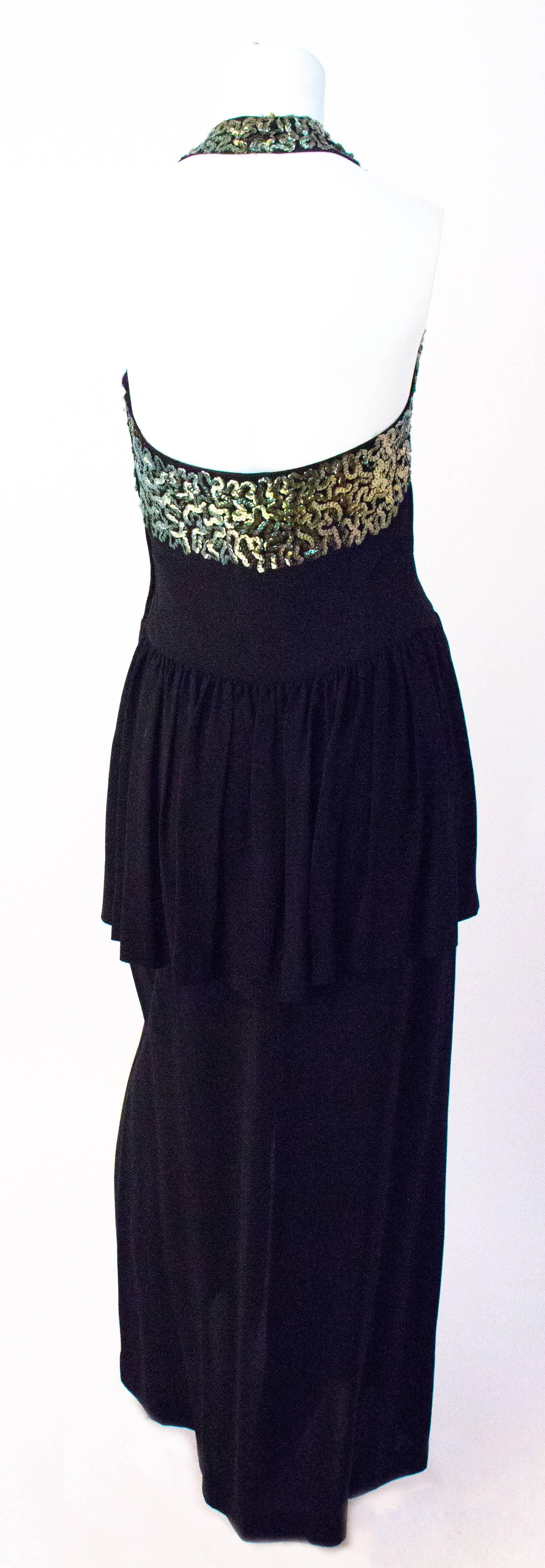 40s Black Crepe Halter Evening Gown with Green Sequined Embellishment on Bodice. Peplum. Metal zipper up the side. 

Front dancing slit: 13 1/2 inches
