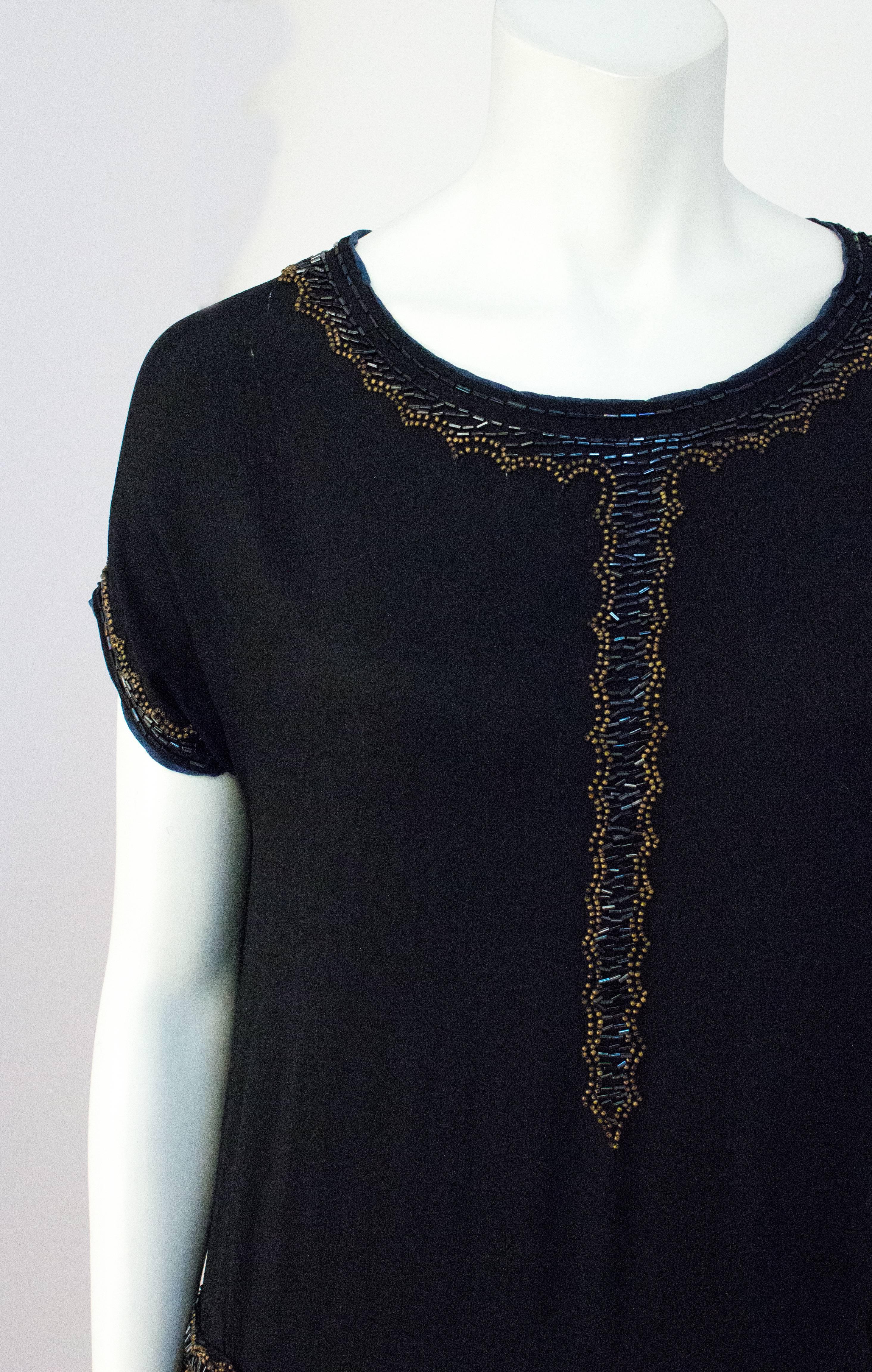20s Black Silk Drop Waist Dress with Gold & Green Beading. Beaded trim along collar, short sleeves and at either hip. Unlined. 