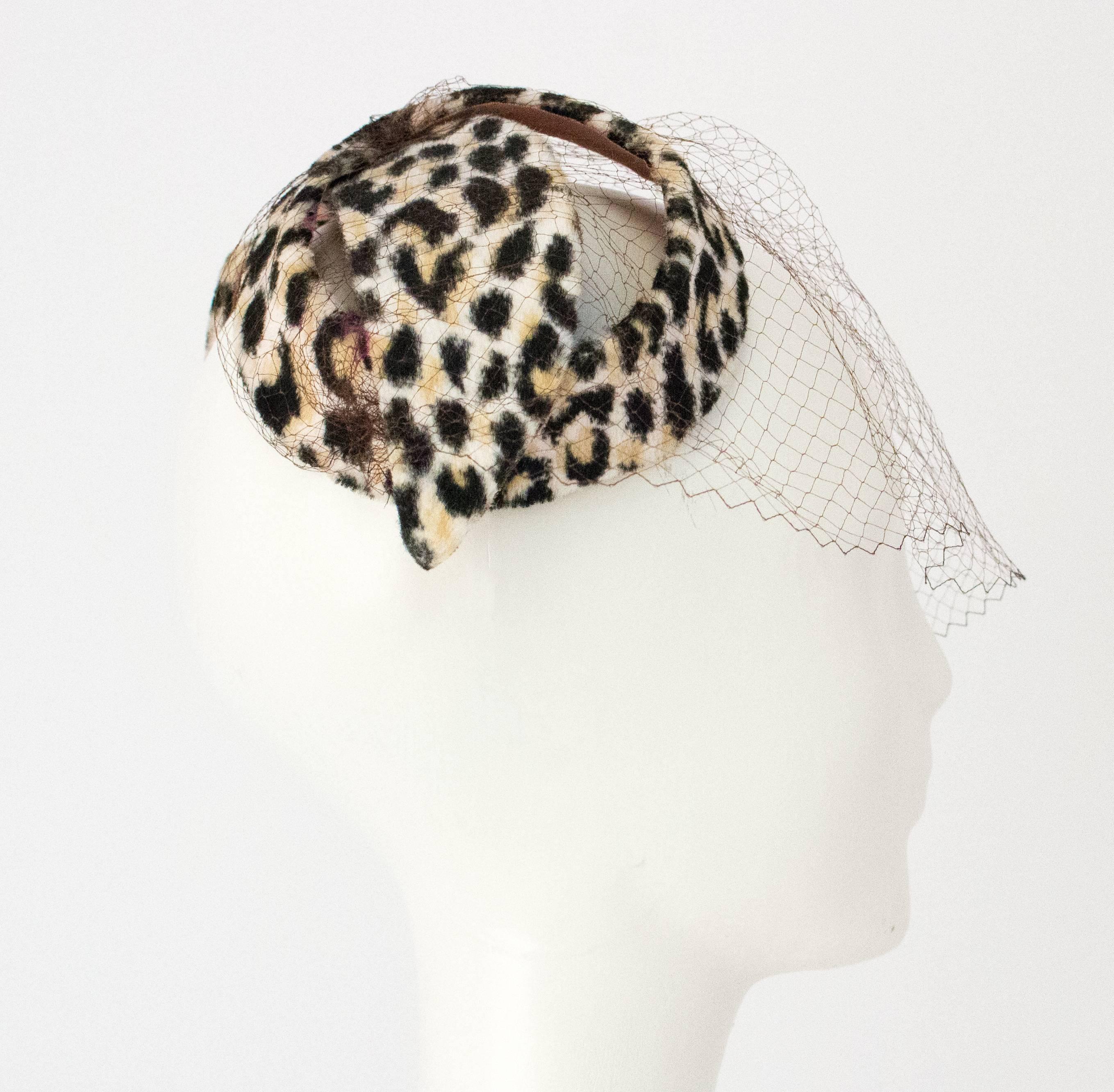 50s Velvet Leopard Print Bow Shaped Hat with Net. Net is a very dark brown. The hat has been shaped into the bow, and is not soft. 

Measurements:
Approx. 11 1/2 inches across 
Approx. 4 1/2 inches wide  