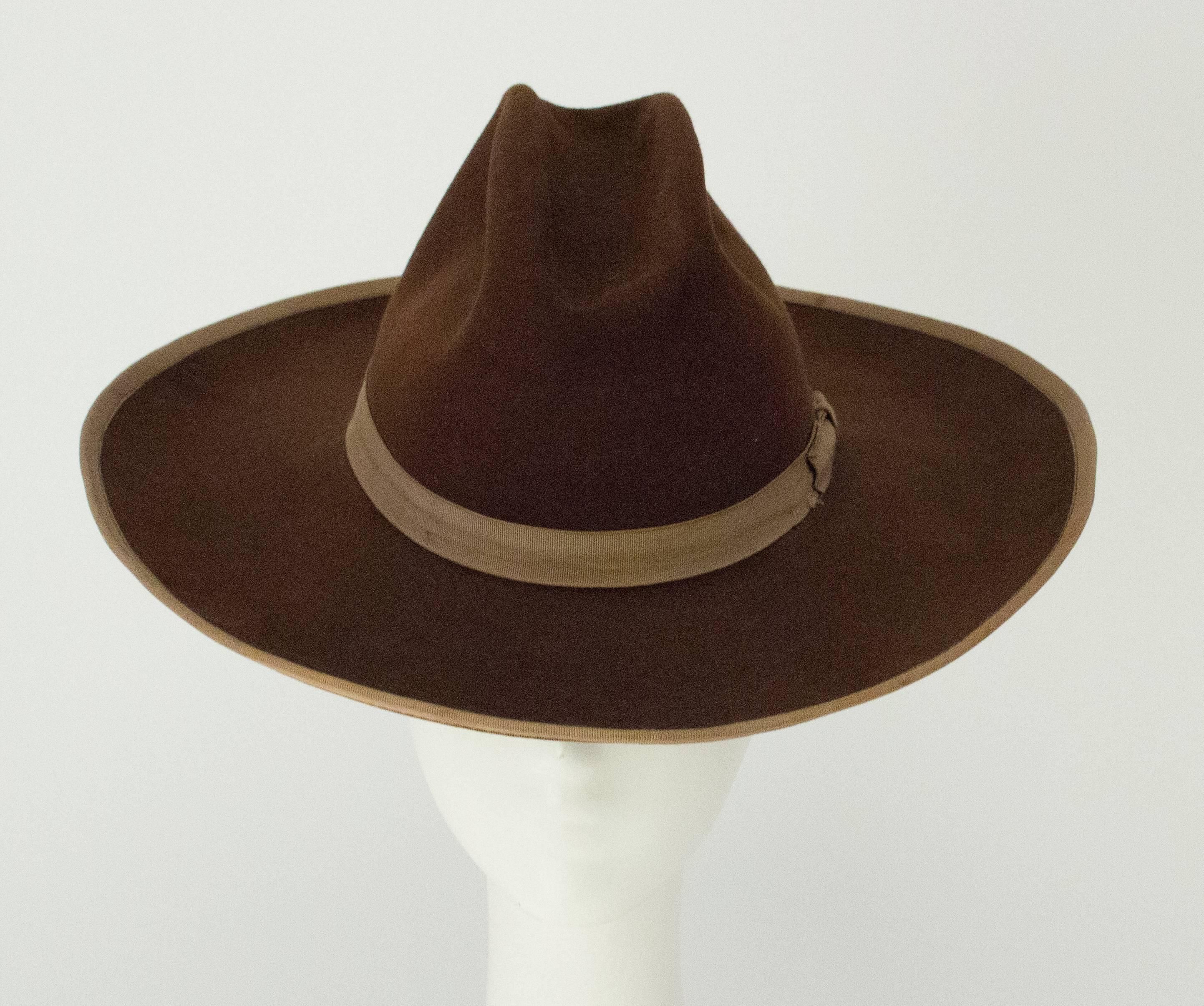 40s Brown Felt Cowboy Hat with Tan Grosgrain Ribbon Trim & Band. Leather interior band. 

Measurements:
Interior circumference: 21 inches 
Brim: Approx. 4 inches wide 
Height: Approx. 5 inches 