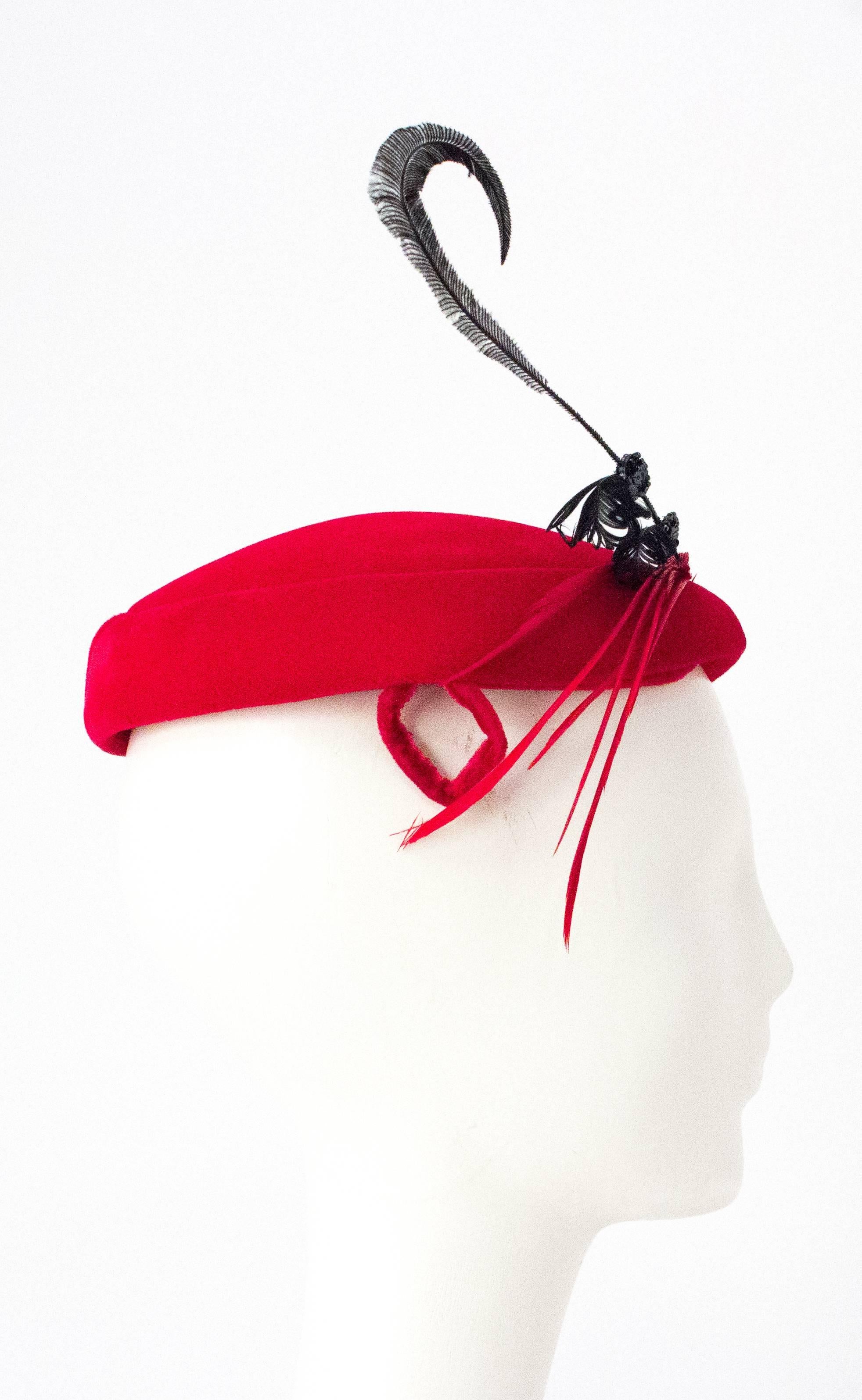 50s Red Velvet Cocktail Hat Adorned with Gems and Feathers. Measures 9 inches from front to back and 9 inches from side to side. 