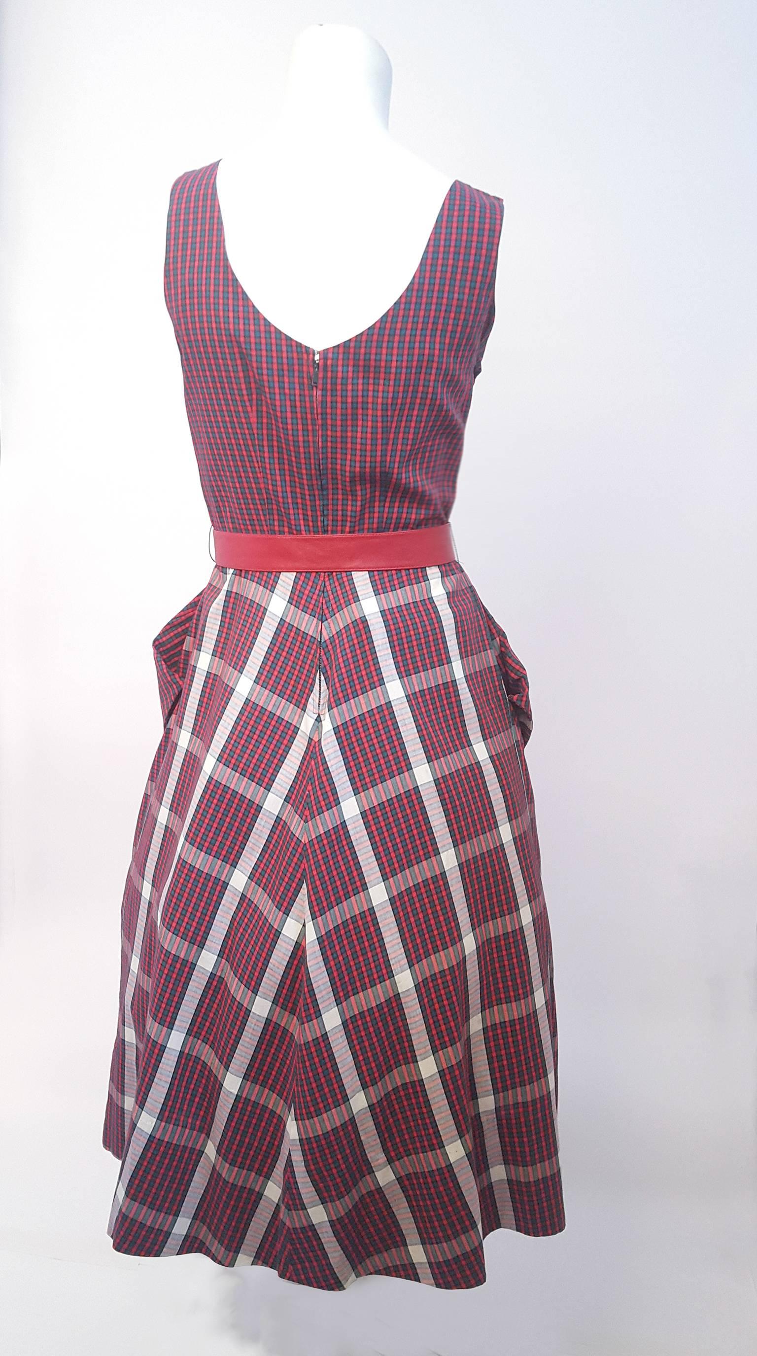 50s Red and Green Tartan Day Dress. Side pockets. Comes with belt a complementary 1950s red belt to accent the waist silhouette. Back zip closure. Shown over petticoat in photos.