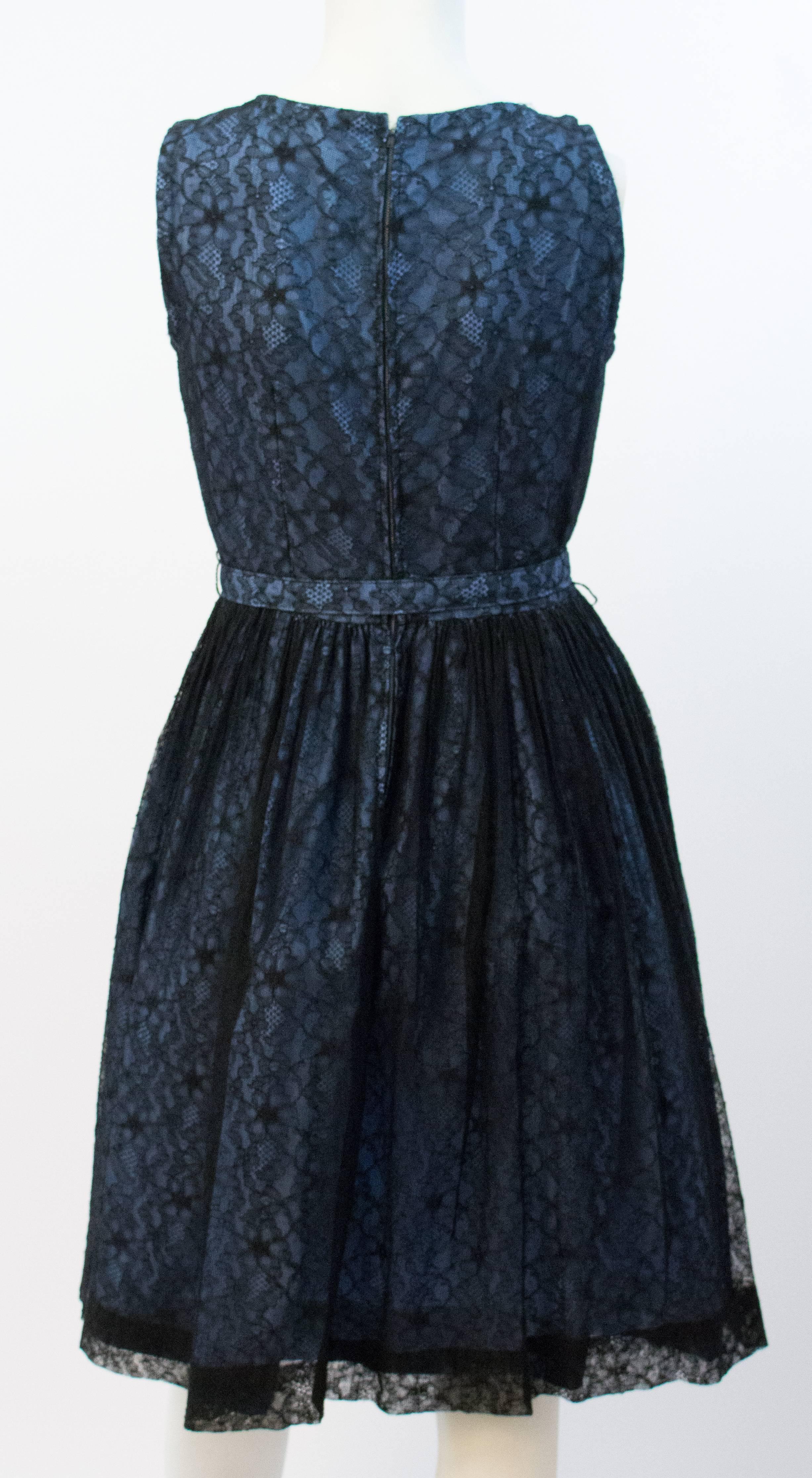 50er Jahre Schwarz-Blaues Spitzenkleid. Schwarze Spitze über blauem Futter. Original-Gürtel. Metallreißverschluss auf der Rückseite.