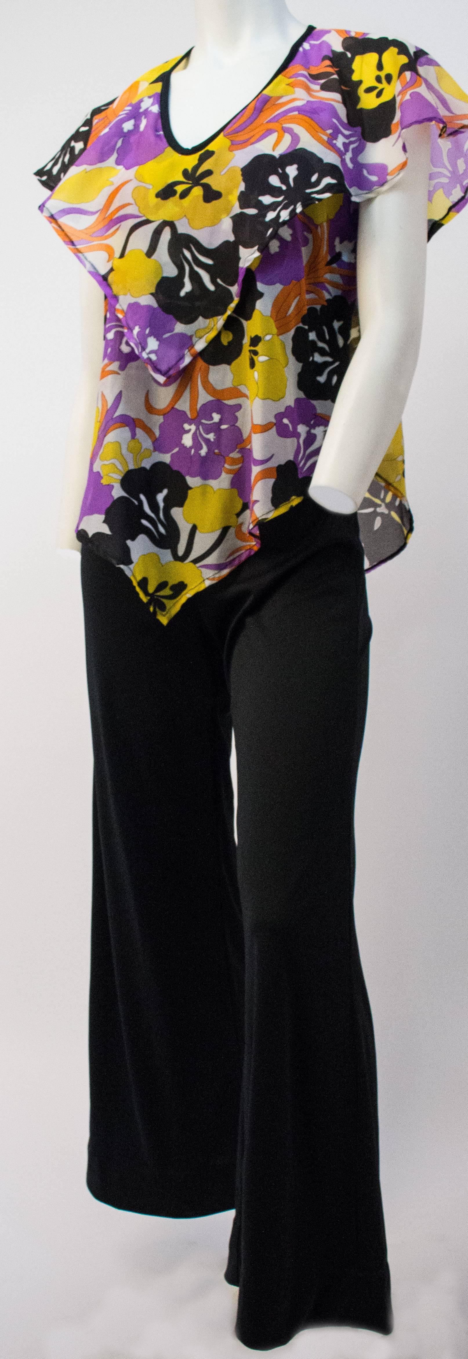 70s Jumpsuit w/ Handkerchief Top. Jersey knit flared pants w/ floral chiffon handkerchief hem bodice. Back zip closure.

Bust: 34 inches
Waist: 28 inches
Hip: 34 inches
Length: 57 inches

In our opinion it is a size small.