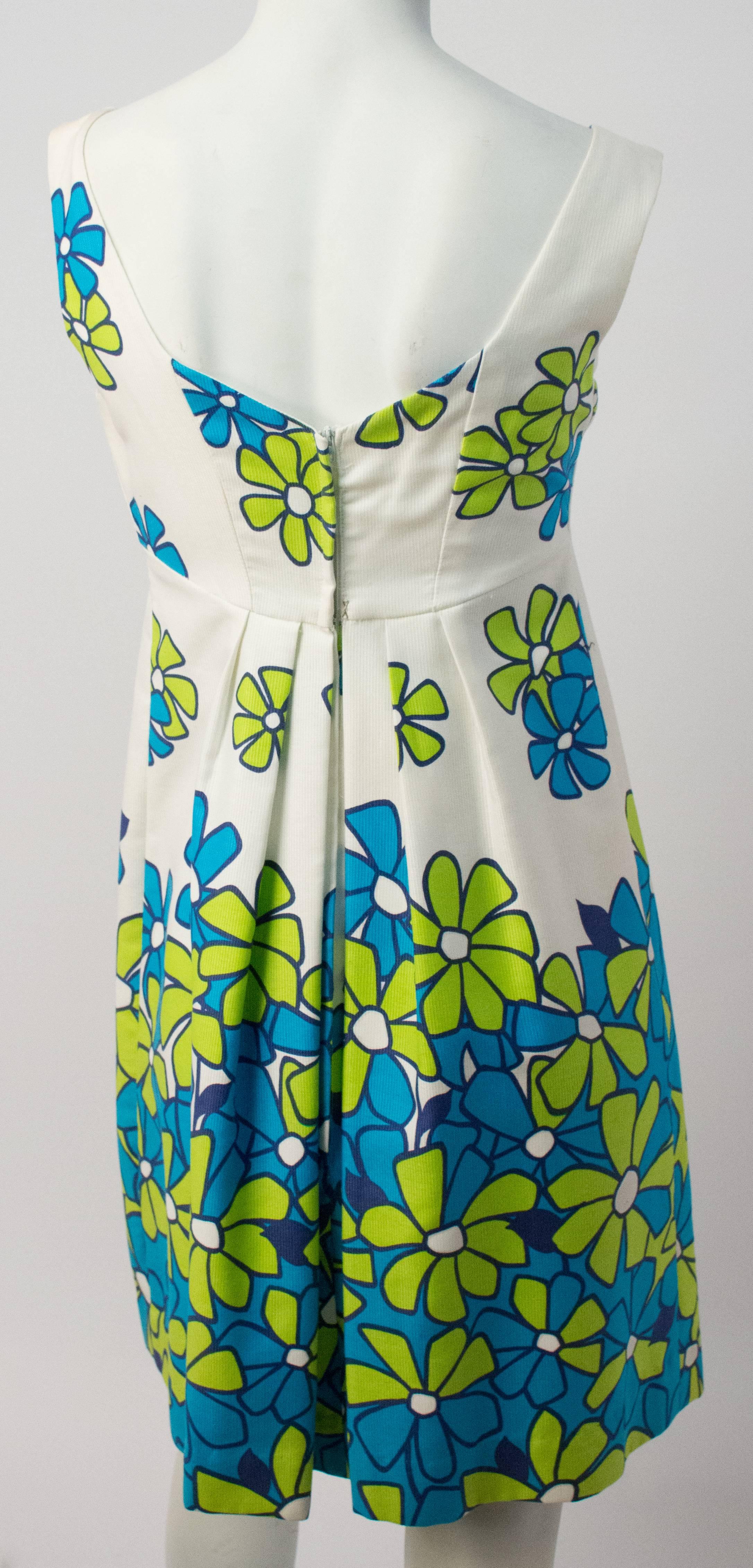 60s Hawaiian Print Daisy Mini Dress. Back zip closure. Grosgrain ribbon bow detail. Bodice is lined in cotton.