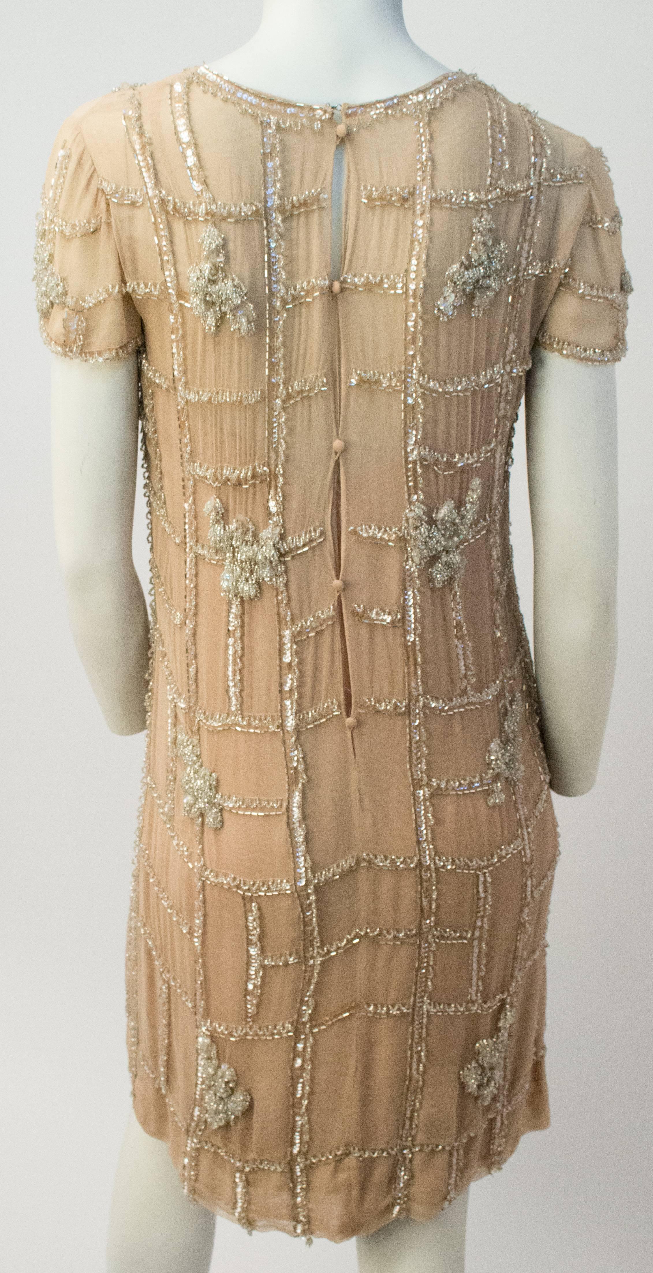 60s Malcom Starr Beaded Nude Cocktail Dress. Dress consists of an outer layer of sheer beaded jersey over nude silk crepe. Lining zips up back with metal zipper, outer closes using covered buttons. 