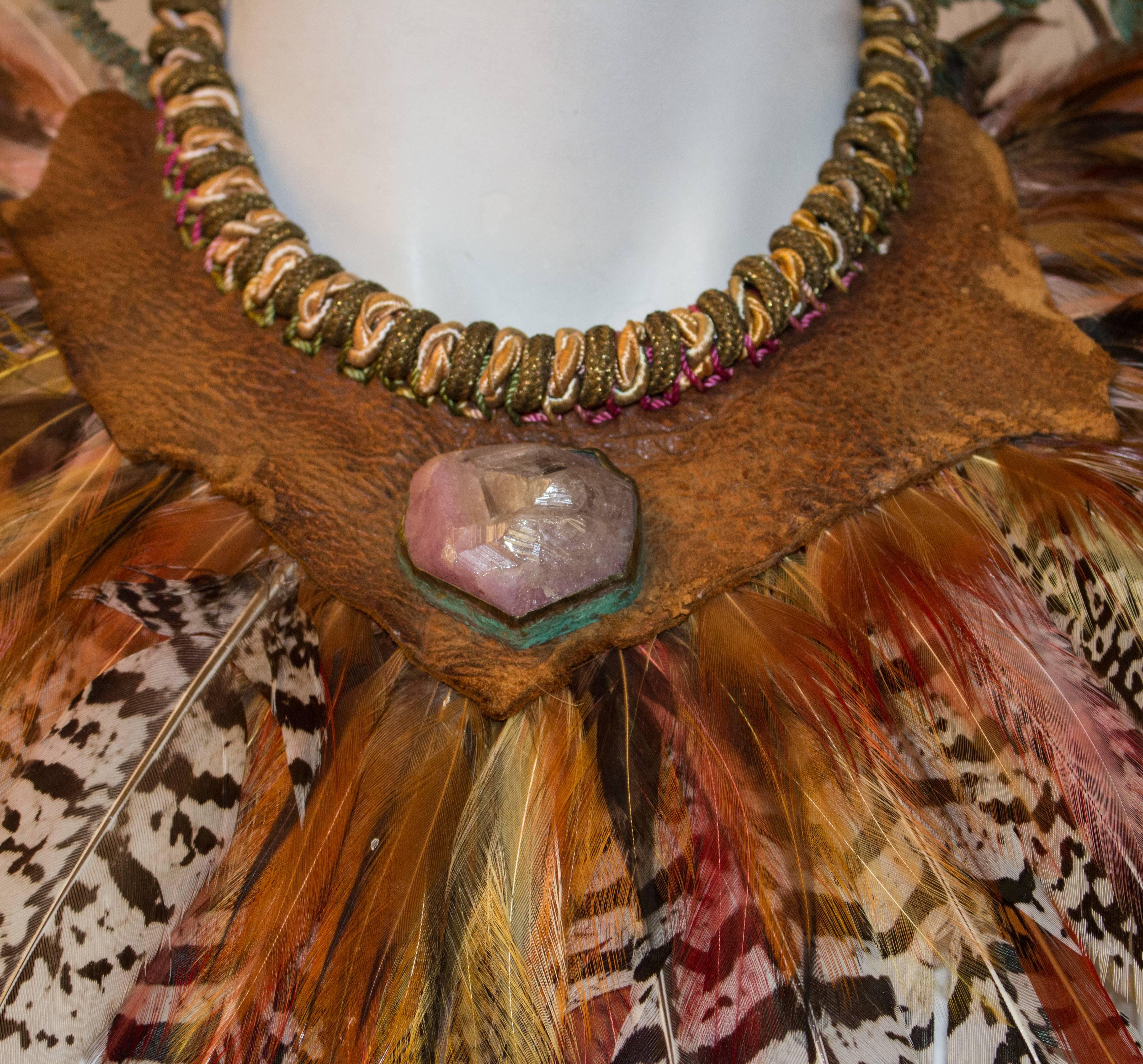 70s Alex and Less Feathered Rope Collar. Necklace is woven rope supported on hammered copper wire, onto which feathers are attached. Leather detail set with an amethyst. Brass hook clasps onto a braided rope hook. 

14
